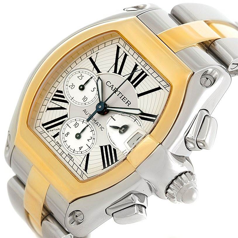 The image shows a Cartier Roadster W62027Z1 Men's Steel and Gold (two tone) Silver Dial W62027Z1 Men's Steel and Gold (two tone) Silver Dial watch at an angle highlighting the face, crown, and bracelet.