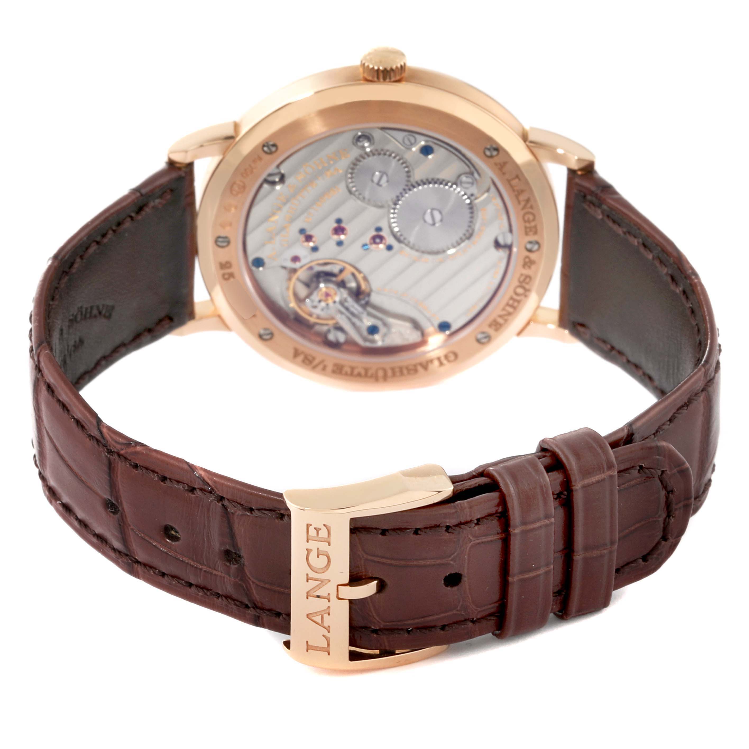 The image shows the back view of the A. Lange & Sohne Saxonia 201.033 Men's Rose Gold Silver Dial watch, highlighting its movement and leather strap with a "LANGE" buckle.