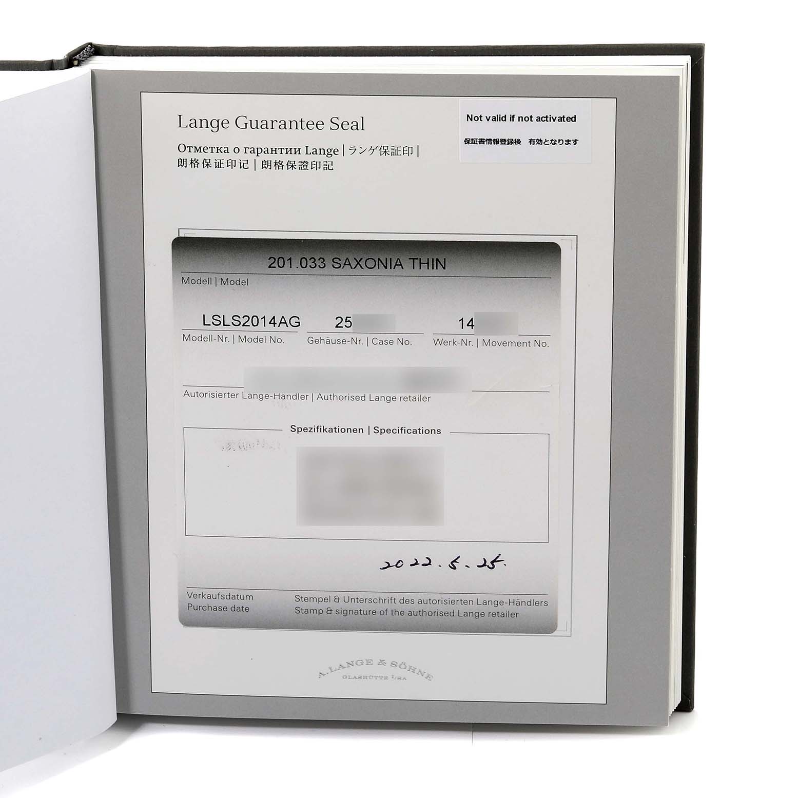 This image shows the certificate and guarantee card for the A. Lange & Sohne Saxonia model watch, taken from a top angle.