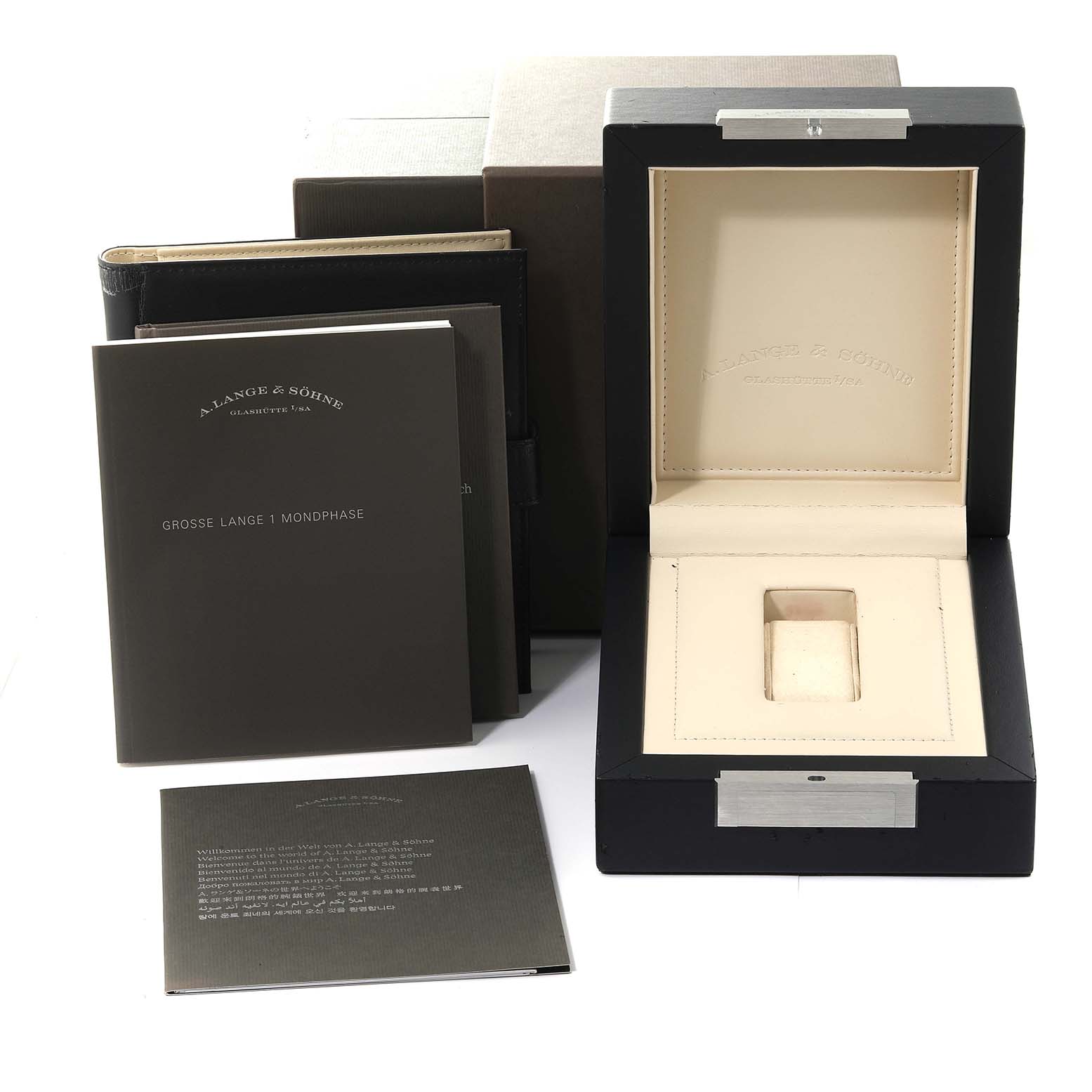 The image shows the packaging and manuals for the Lange 1 model by A. Lange & Sohne, including the watch box and booklets.