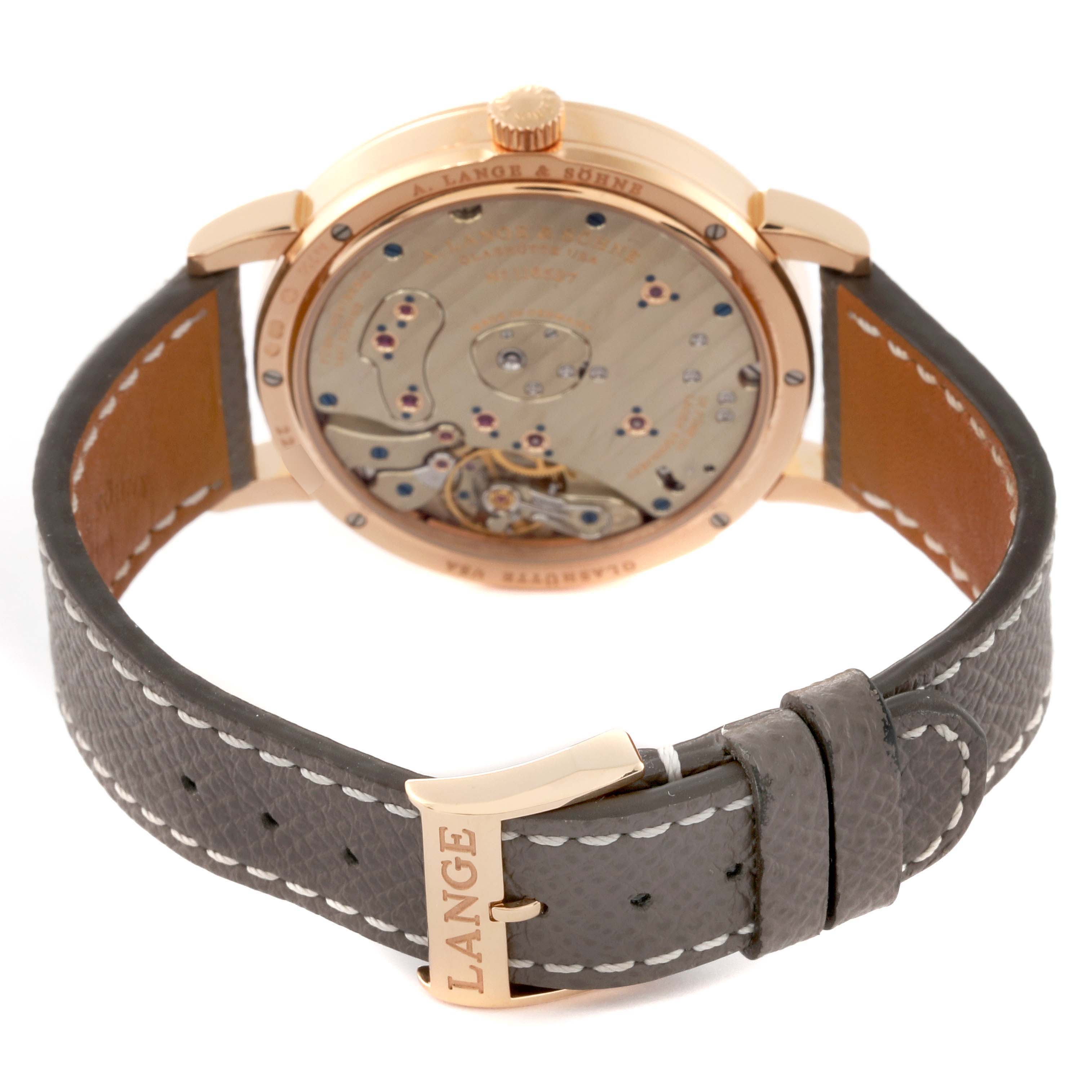The image shows the rear view of the Lange 1 model by A. Lange & Söhne, displaying the movement and leather strap with branded buckle.