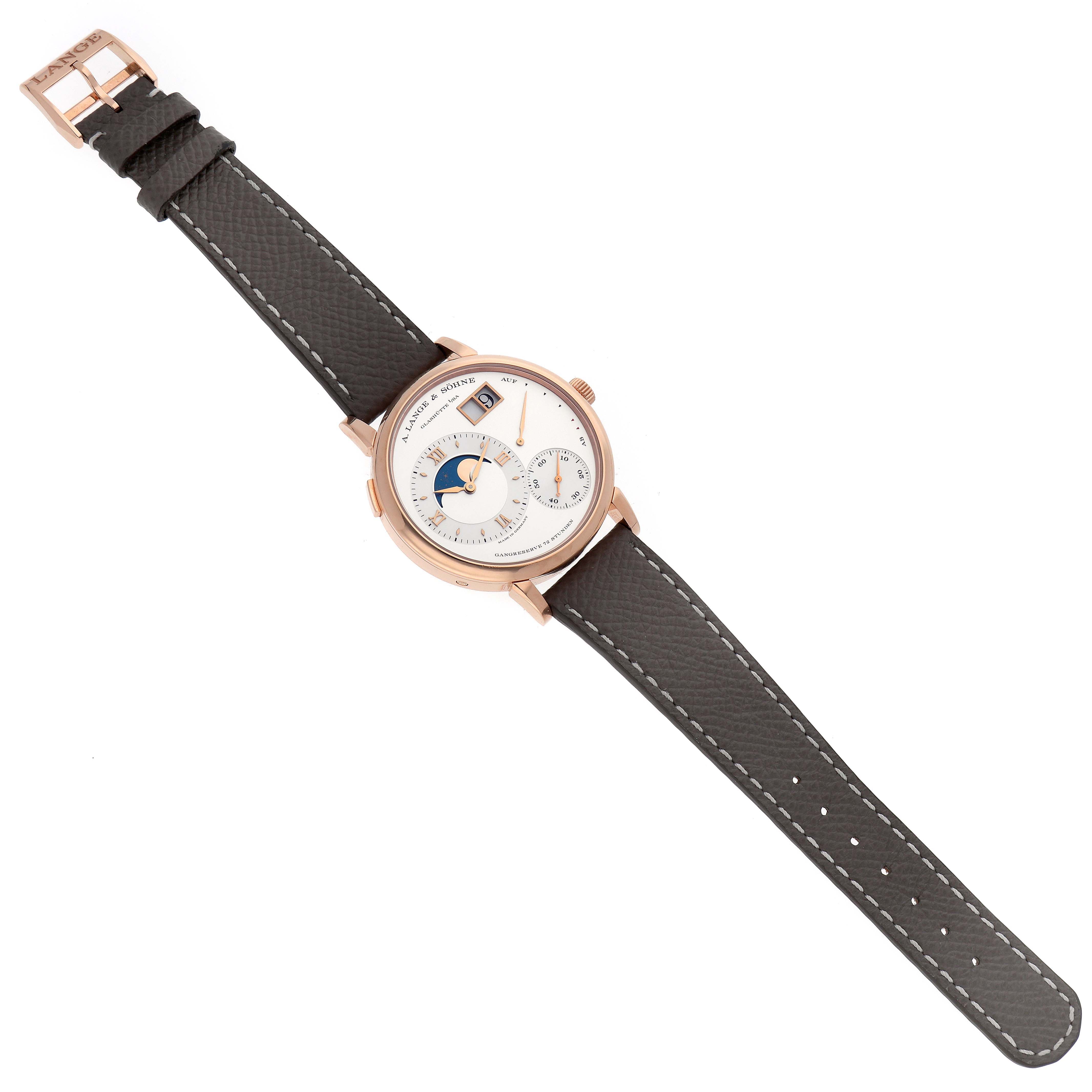 The A. Lange & Sohne Lange 1 139.032 Men's Rose Gold Silver Dial watch is shown from a top-down angle, displaying the face, straps, and buckle.