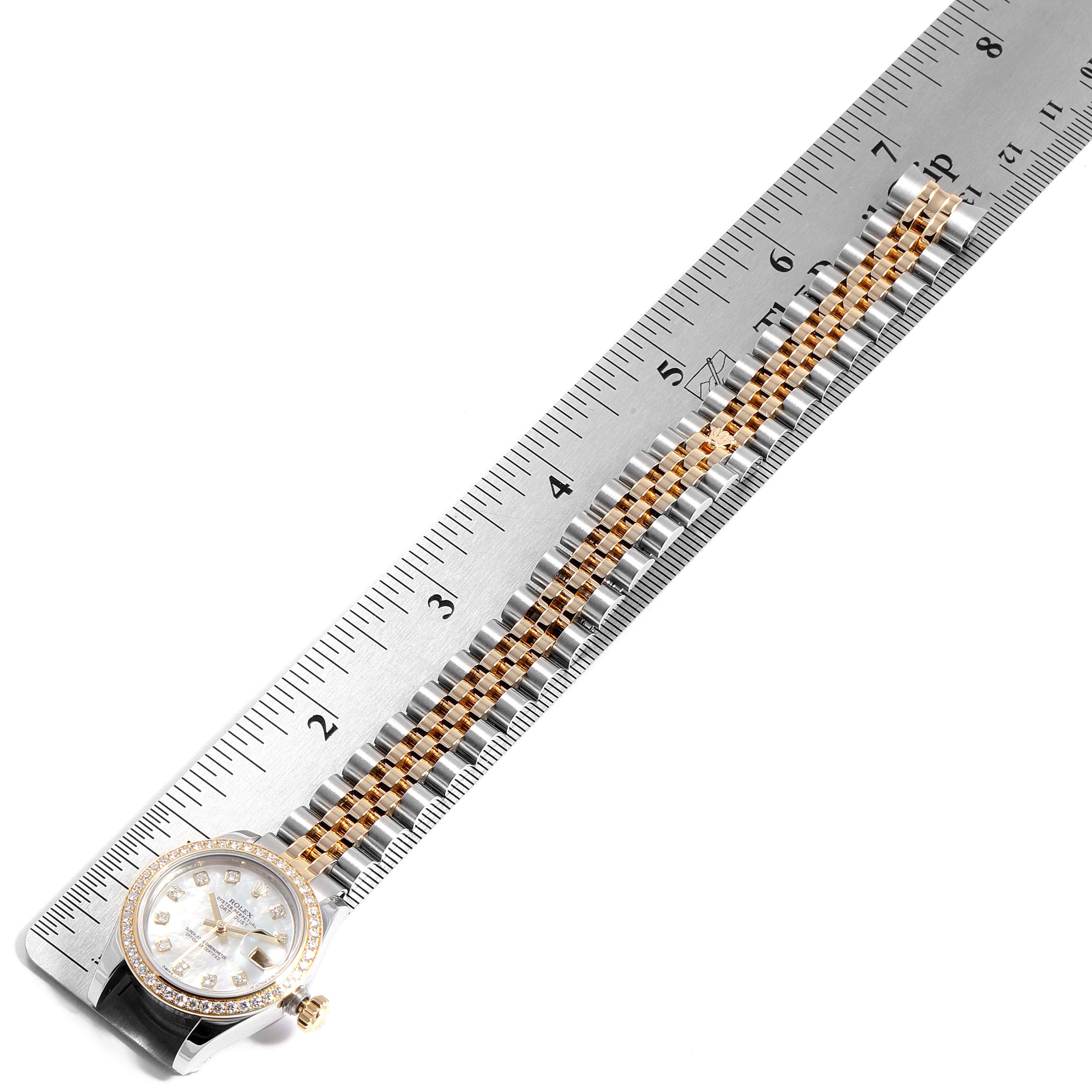 The Rolex Datejust 179383 Women's Steel and Gold (two tone) Mother of Pearl Dial 179383 Women's Steel and Gold (two tone) Mother of Pearl Dial watch is shown from the top, displaying its dial, bezel, and the bracelet next to a ruler.