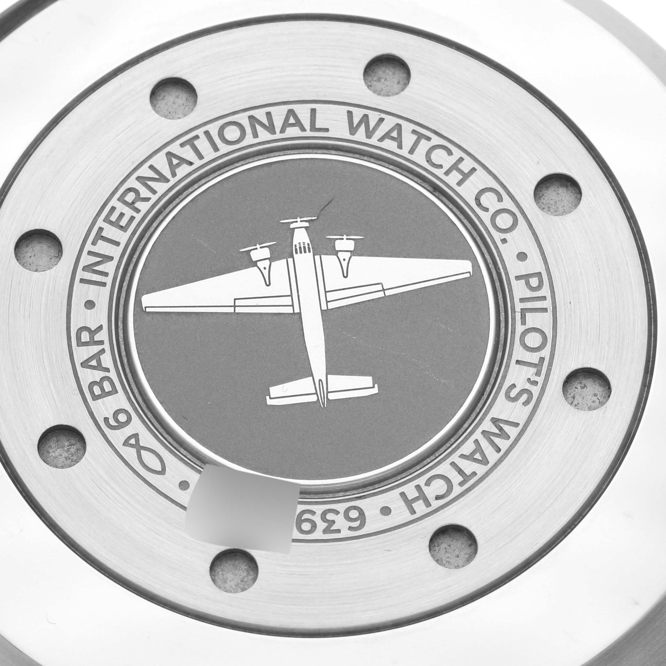 This image shows the back case of the IWC Pilot IW501001 Men's Stainless Steel Black Dial IW501001 Men's Stainless Steel Black Dial model watch, featuring an airplane engraving.
