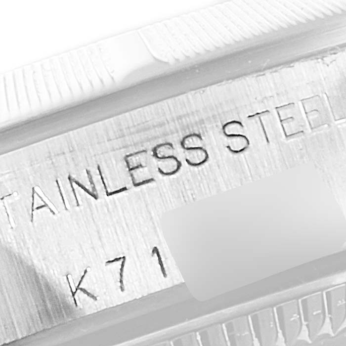 This is a close-up angle showing the stainless steel engraving on the bezel or case of the Rolex Oyster Perpetual 76030 Women's Stainless Steel White Dial 76030 Women's Stainless Steel White Dial watch.