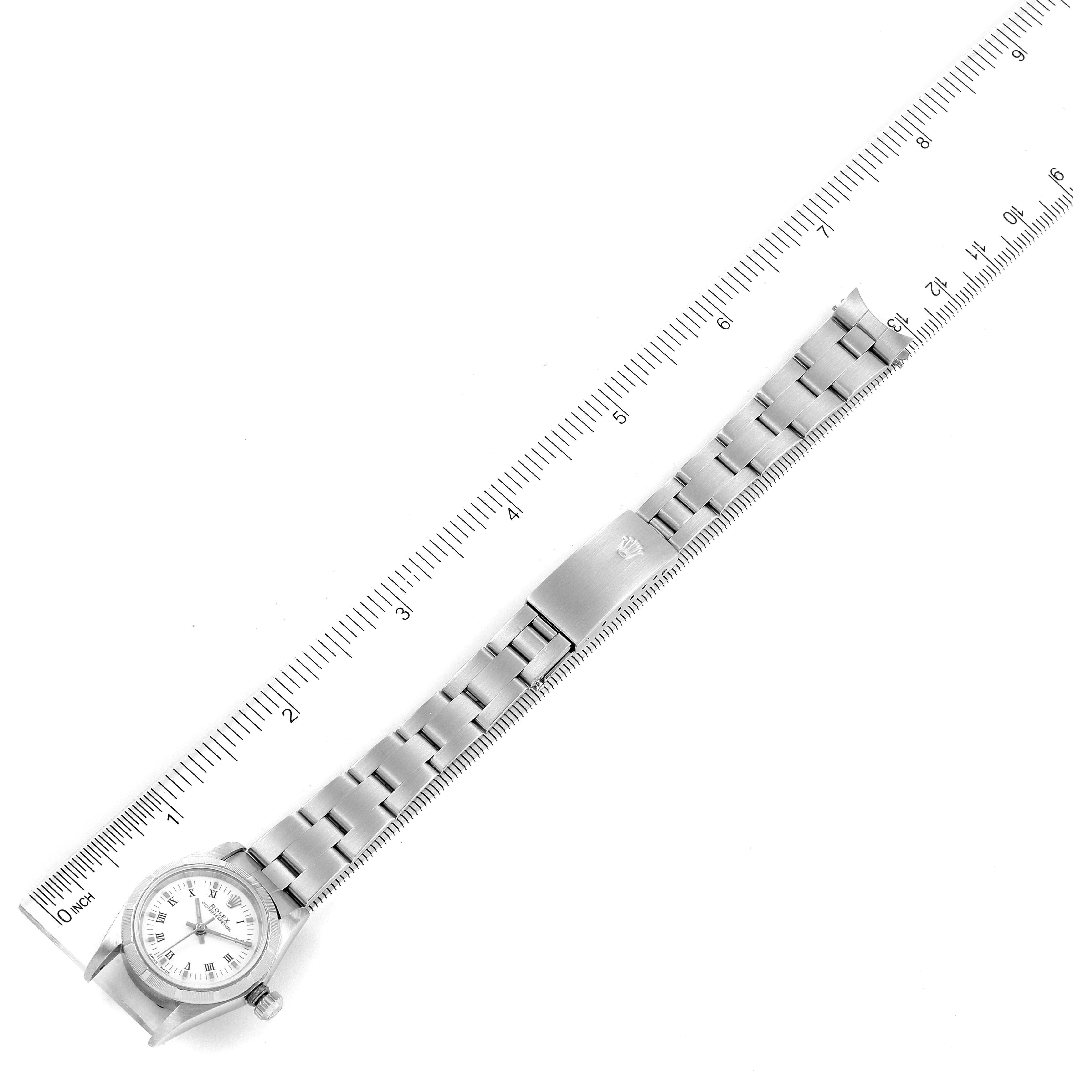 This image shows a top-down view of a Rolex Oyster Perpetual 76030 Women's Stainless Steel White Dial 76030 Women's Stainless Steel White Dial watch alongside a ruler, displaying the bracelet and watch face.