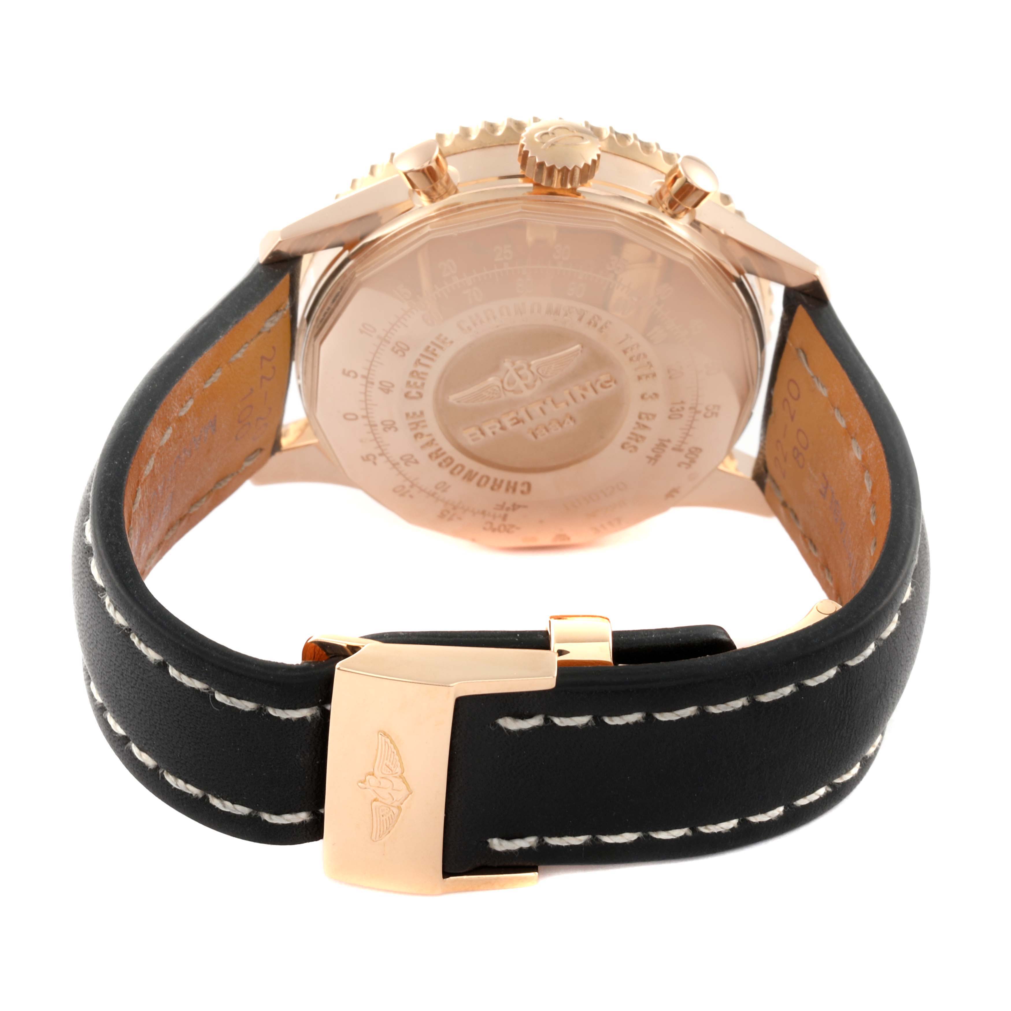 This image shows the back side of a Breitling Navitimer RB0120 Men's Rose Gold Black Dial RB0120 Men's Rose Gold Black Dial watch with a black leather strap and gold clasp.