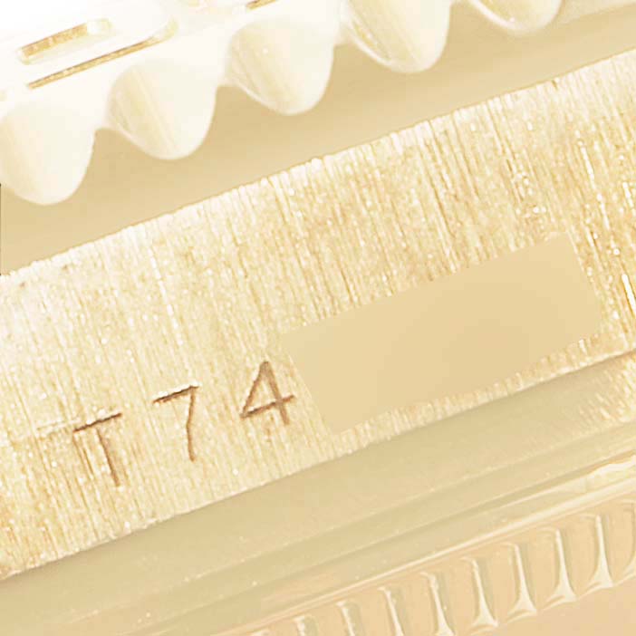 This close-up image of a Rolex Yacht-Master 68628 Men's Yellow Gold White Dial 68628 Men's Yellow Gold White Dial watch shows the edge of the bezel and part of the case marked "T 74".