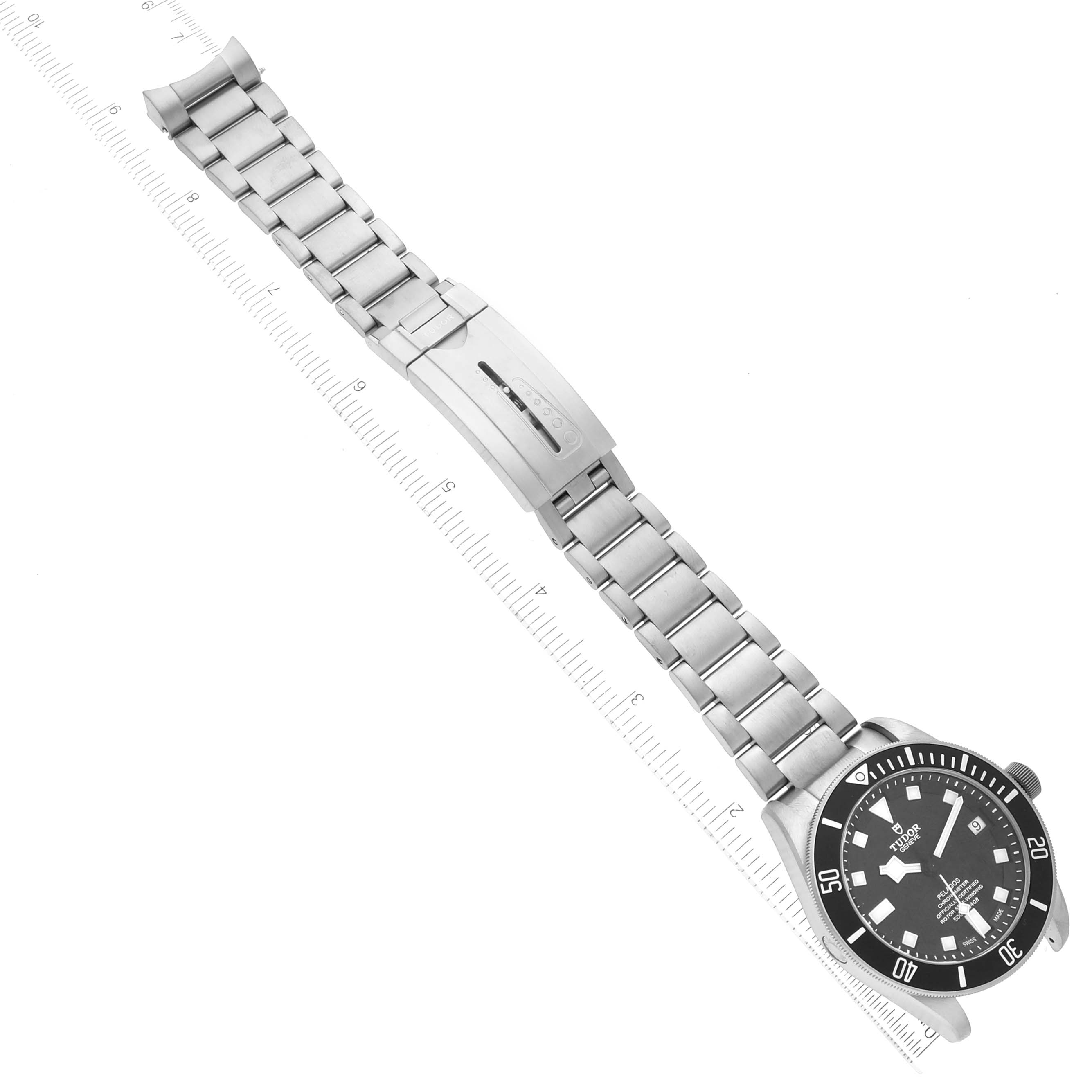 The image shows a Tudor Pelagos 25600TN Men's Titanium Black Dial 25600TN Men's Titanium Black Dial watch, displayed flat and measured on a ruler, featuring its black dial and metal bracelet with clasp.