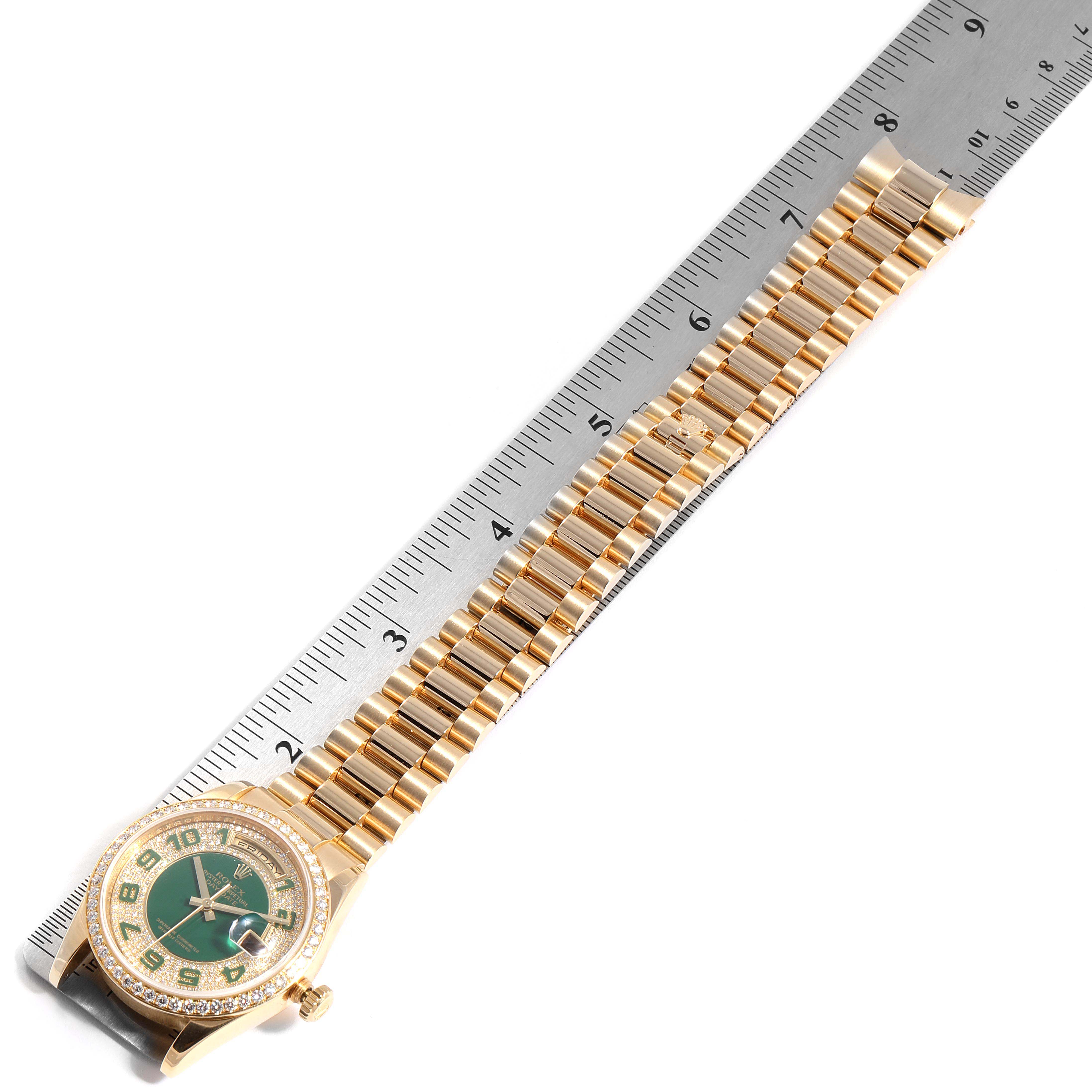 The image shows the President model Rolex watch laid flat, featuring the case, dial, and bracelet next to a ruler for scale.