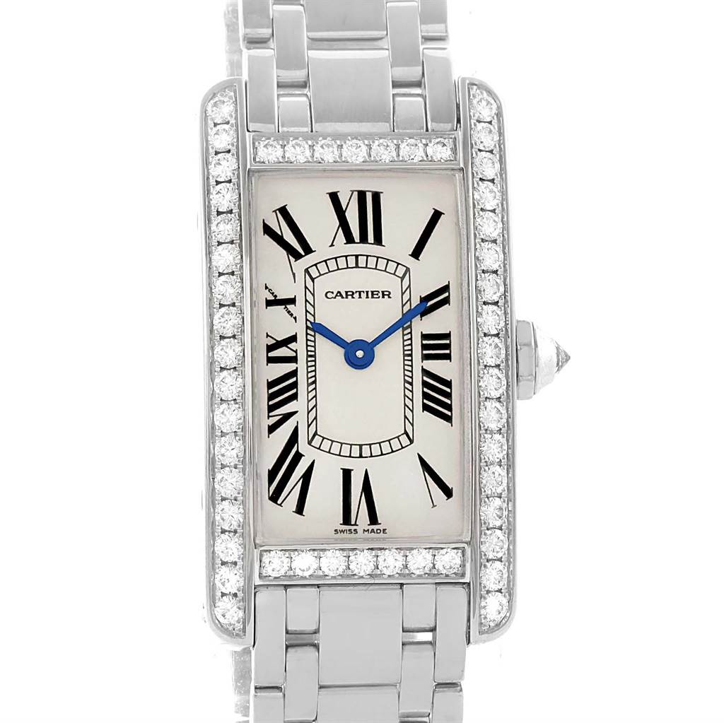The image shows a front view of the Cartier Tank Americaine WB7073L1 Women's White Gold Silver Dial WB7073L1 Women's White Gold Silver Dial watch, highlighting its face, bezel with diamonds, and part of its bracelet.
