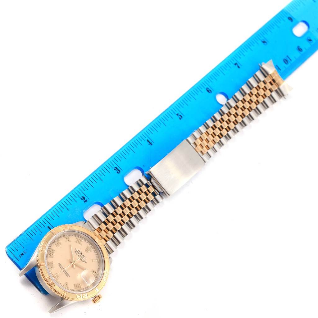 The Rolex Turn-o-Graph 16263 Men's Steel and Gold (two tone) Beige Dial 16263 Men's Steel and Gold (two tone) Beige Dial watch is shown from a top view, highlighting the face, bezel, and bracelet beside a ruler for size reference.