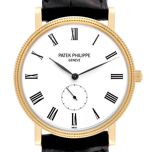 This image shows a Patek Philippe Calatrava 5119J Men's Yellow Gold White Dial 5119J Men's Yellow Gold White Dial model watch from a front angle displaying its face, roman numerals, and black strap.