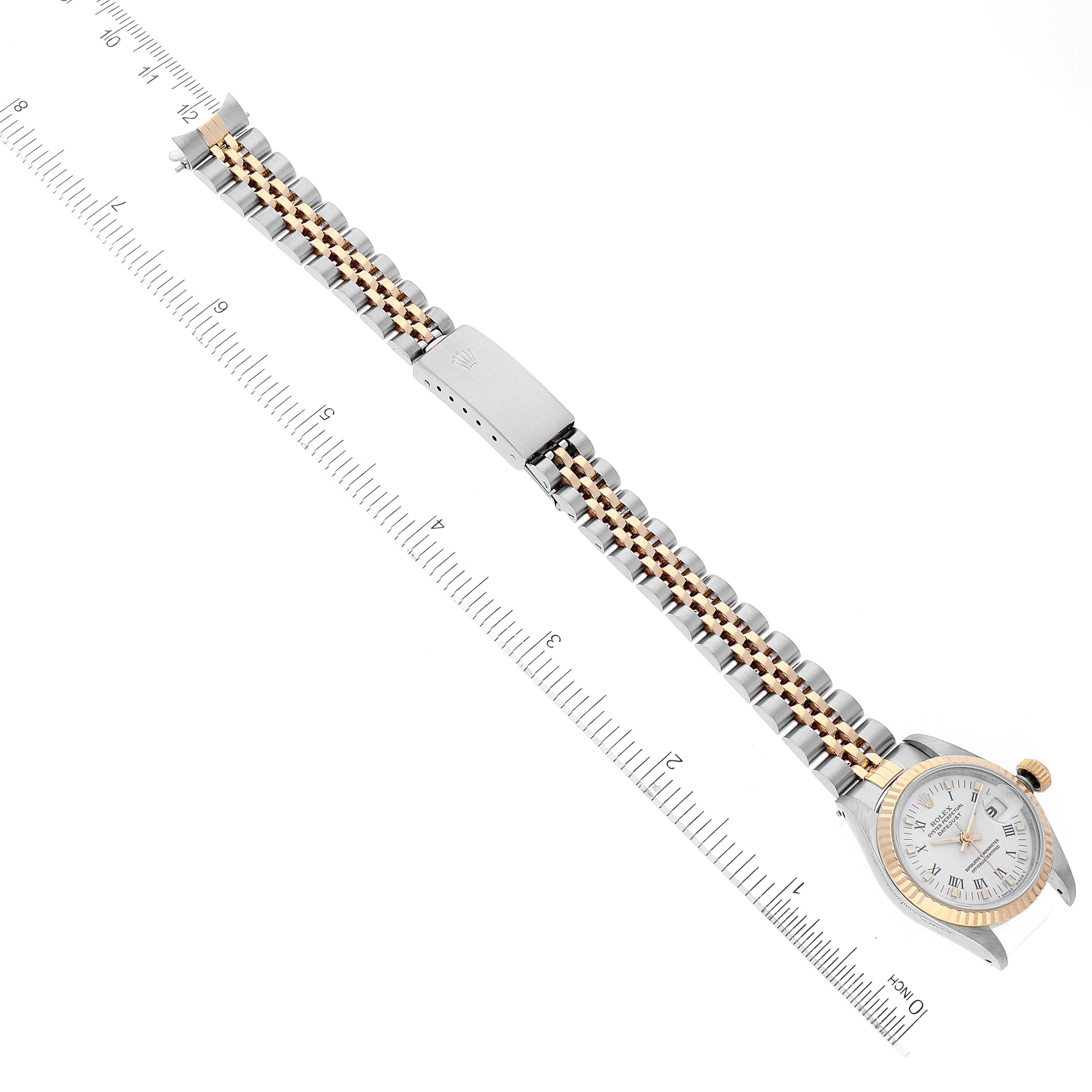 The image shows an overhead view of the Rolex Datejust 69173 Women's Steel and Gold (two tone) White Dial 69173 Women's Steel and Gold (two tone) White Dial watch with its band extended, laid next to a ruler for measurement.
