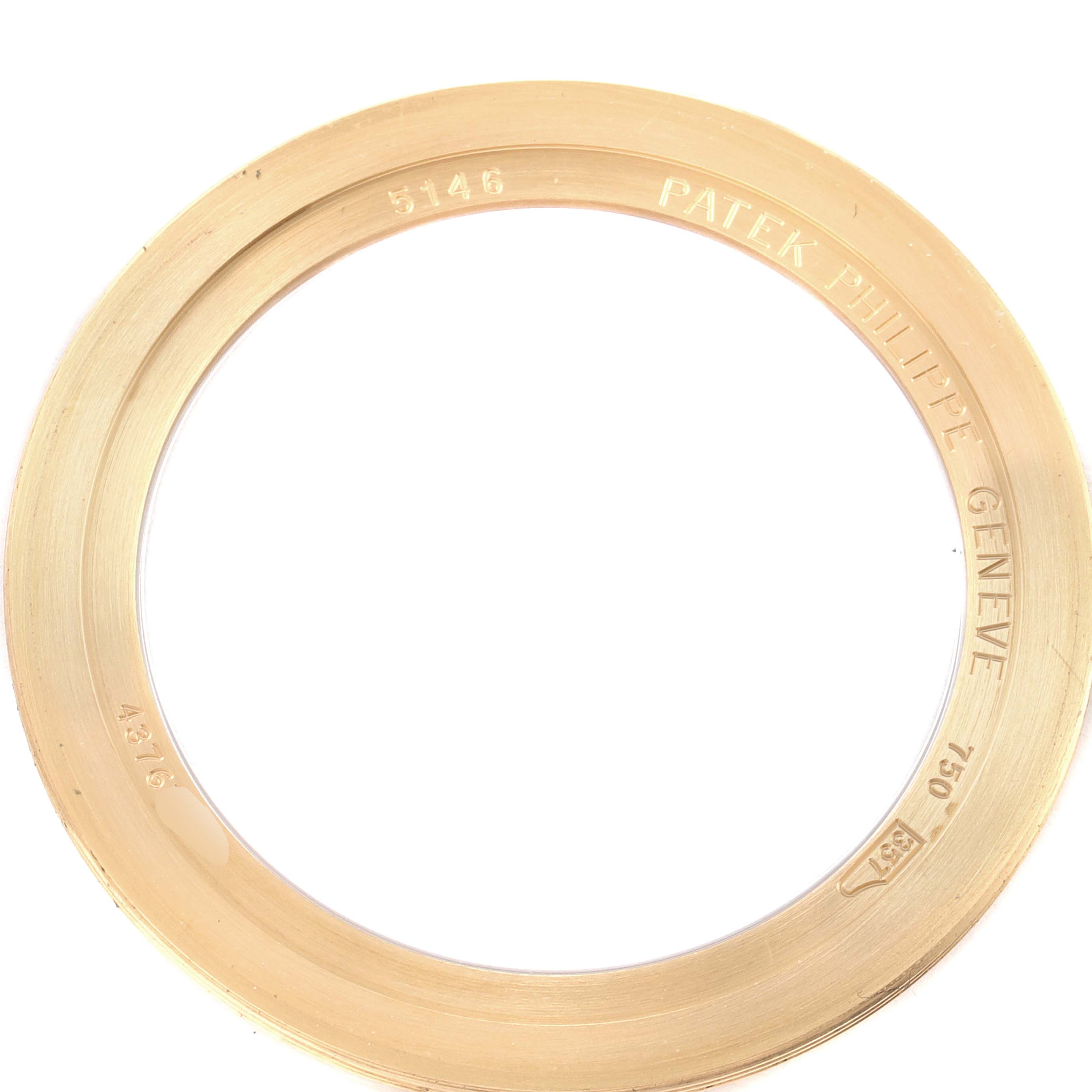 The image shows a close-up view of the yellow gold bezel for the Patek Philippe 5146J - 01D Men's Yellow Gold Grey Dial 5146J - 01D Men's Yellow Gold Grey Dial Complicated Annual Calendar Men's Watch model 5146.