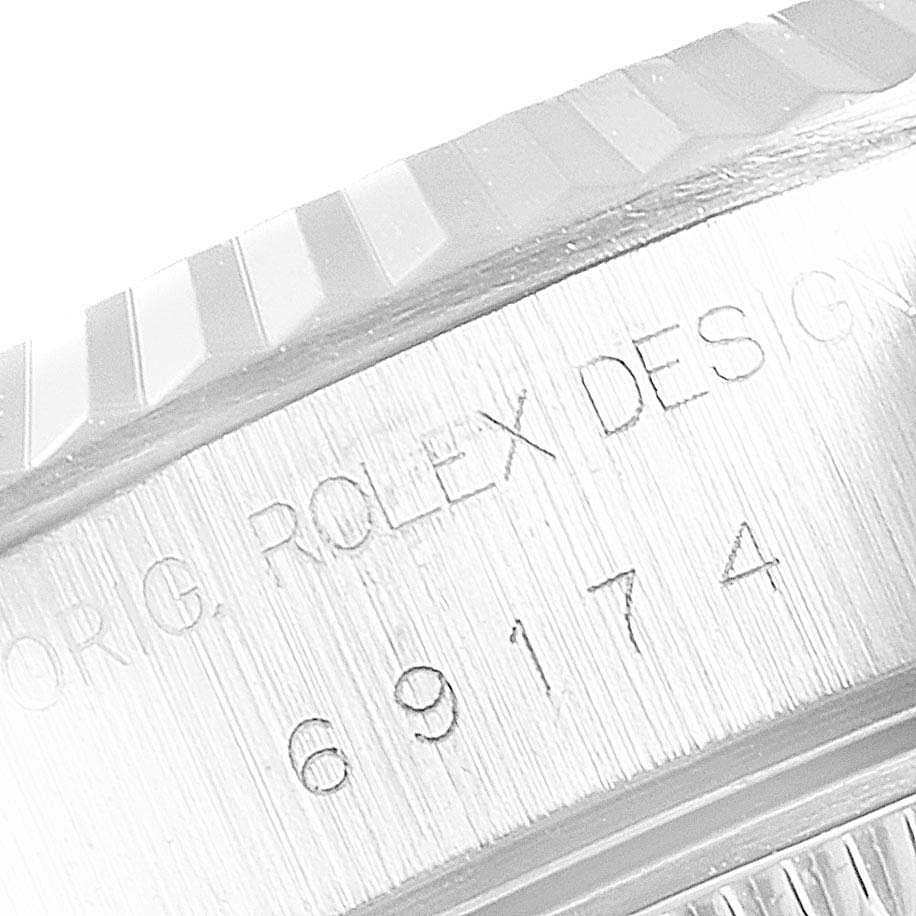 This is a close-up of the model number engraving and fluted bezel of a Rolex Datejust 69174 Women's Stainless Steel Black Dial 69174 Women's Stainless Steel Black Dial watch.