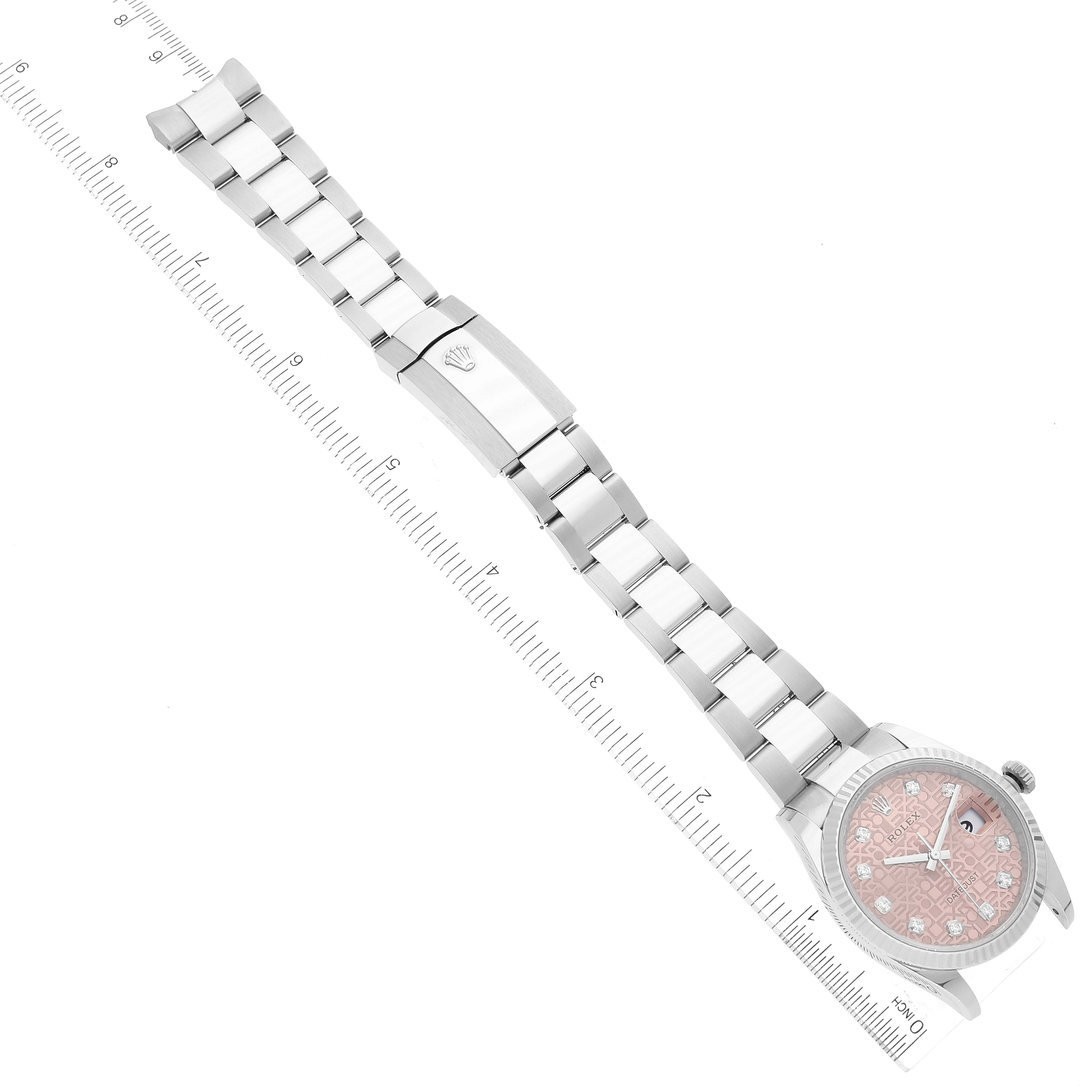 The image shows a Rolex Datejust 126234 Men's Stainless Steel Pink Dial 126234 Men's Stainless Steel Pink Dial watch laid flat, displaying its face, bracelet, and clasp, angled diagonally with a ruler for scale.
