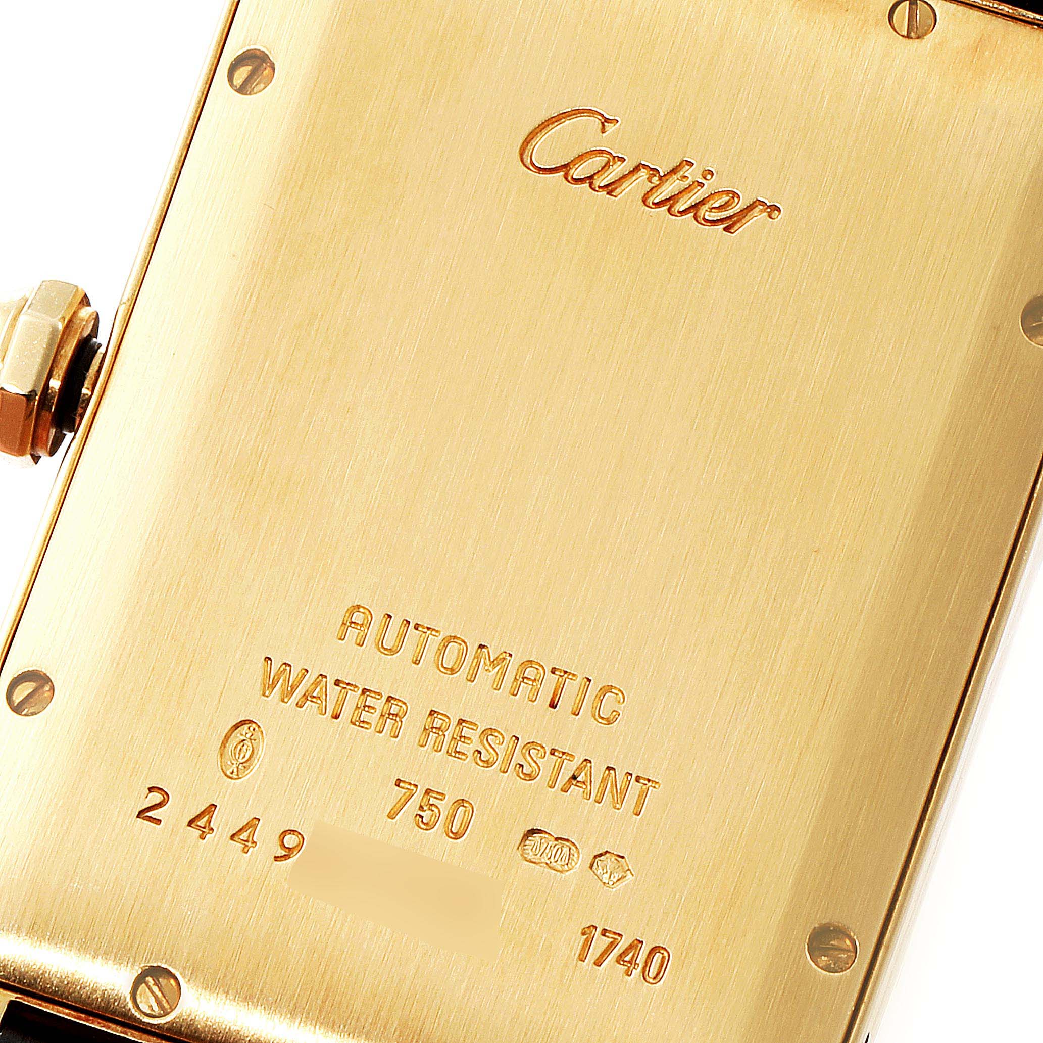 This image shows the backside of a Cartier Tank Americaine W2603156 Men's Yellow Gold Silver Dial W2603156 Men's Yellow Gold Silver Dial watch, highlighting the engraved details and markings.