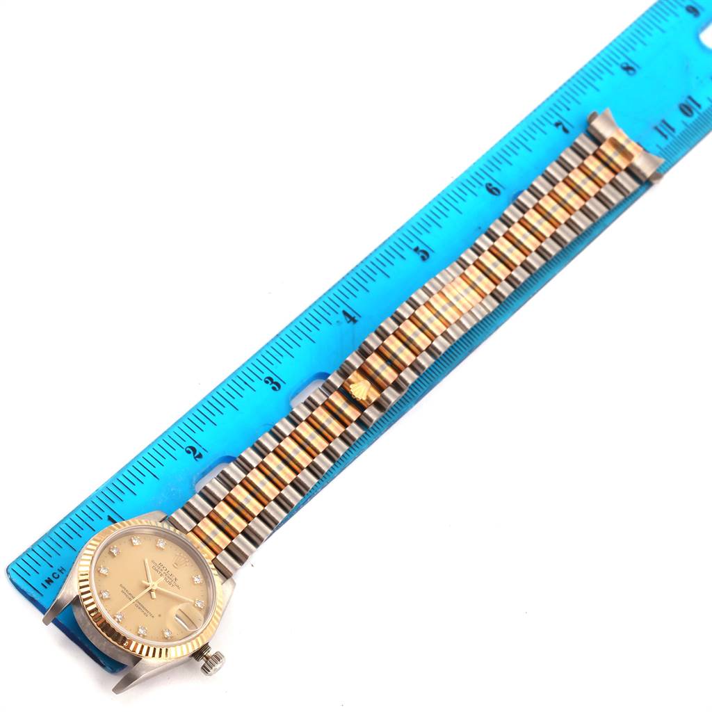 The image shows a Rolex President 68279 Women's White Gold Champagne Dial 68279 Women's White Gold Champagne Dial model watch placed alongside a ruler, highlighting its bracelet and face from a top-down angle.