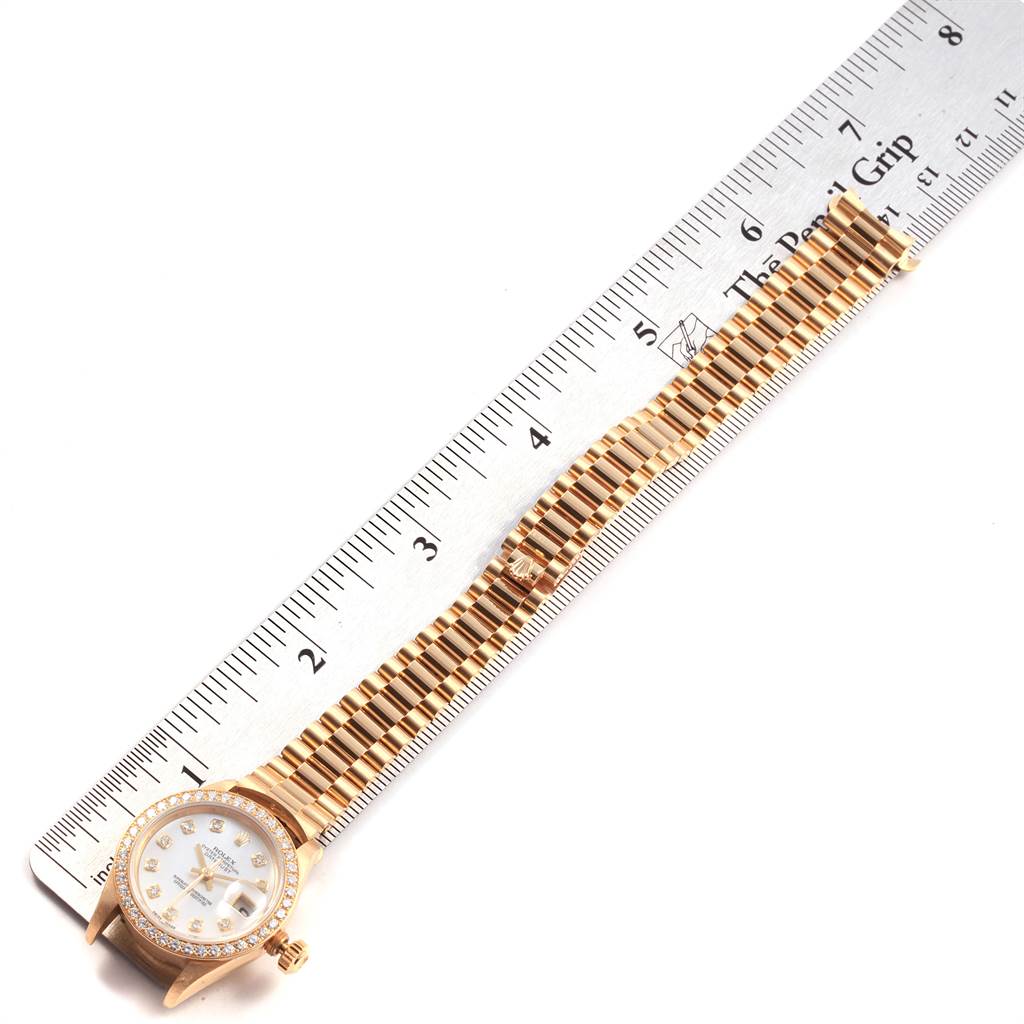The image shows a Rolex President 69138 Women's Yellow Gold Mother of Pearl Dial 69138 Women's Yellow Gold Mother of Pearl Dial watch placed flat next to a ruler, displaying the face and bracelet.
