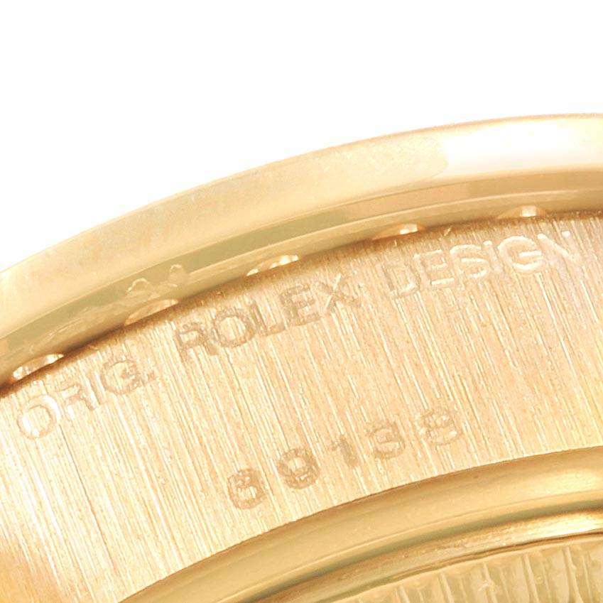 This image shows a close-up of the case back edge of a Rolex President 69138 Women's Yellow Gold Mother of Pearl Dial 69138 Women's Yellow Gold Mother of Pearl Dial model watch, displaying part of the engraving.