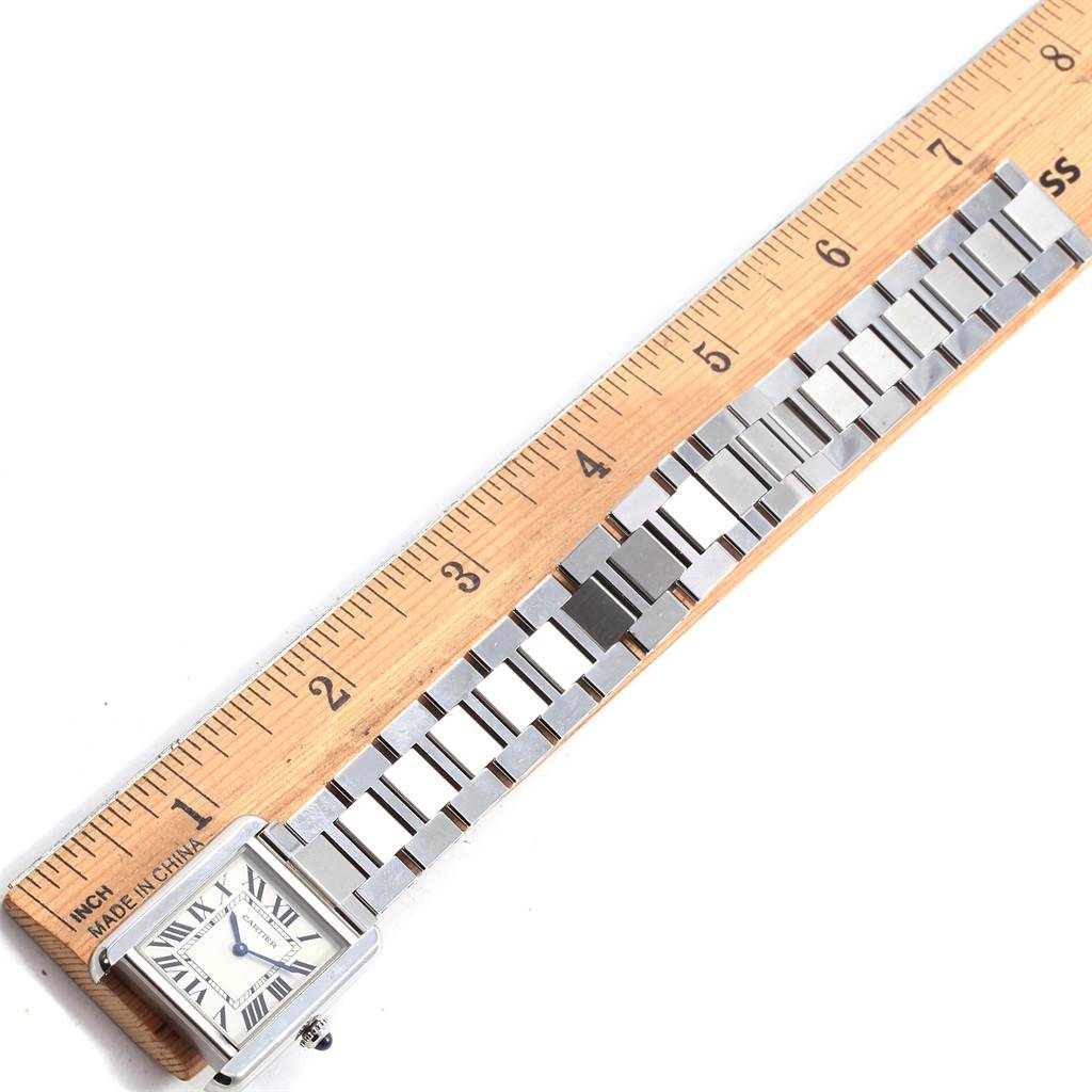 The Cartier Tank Solo W5200013 Women's Stainless Steel Silver Dial W5200013 Women's Stainless Steel Silver Dial watch is shown from the top with the face and bracelet partially measured against a wooden ruler.