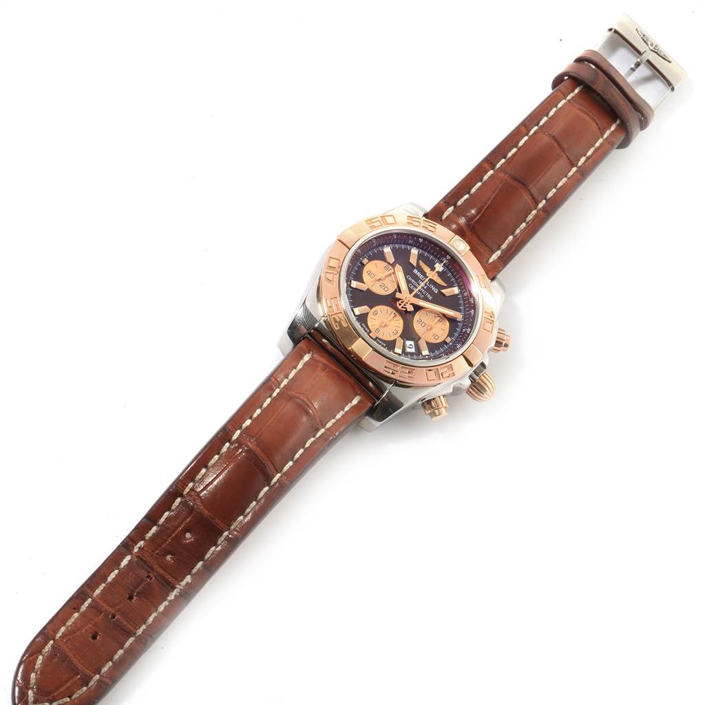 This image shows a Breitling Chronomat CB0110 Men's Steel and Gold (two tone) Brown Dial CB0110 Men's Steel and Gold (two tone) Brown Dial watch from a top-down angle, highlighting its face, bezel, and brown leather strap.