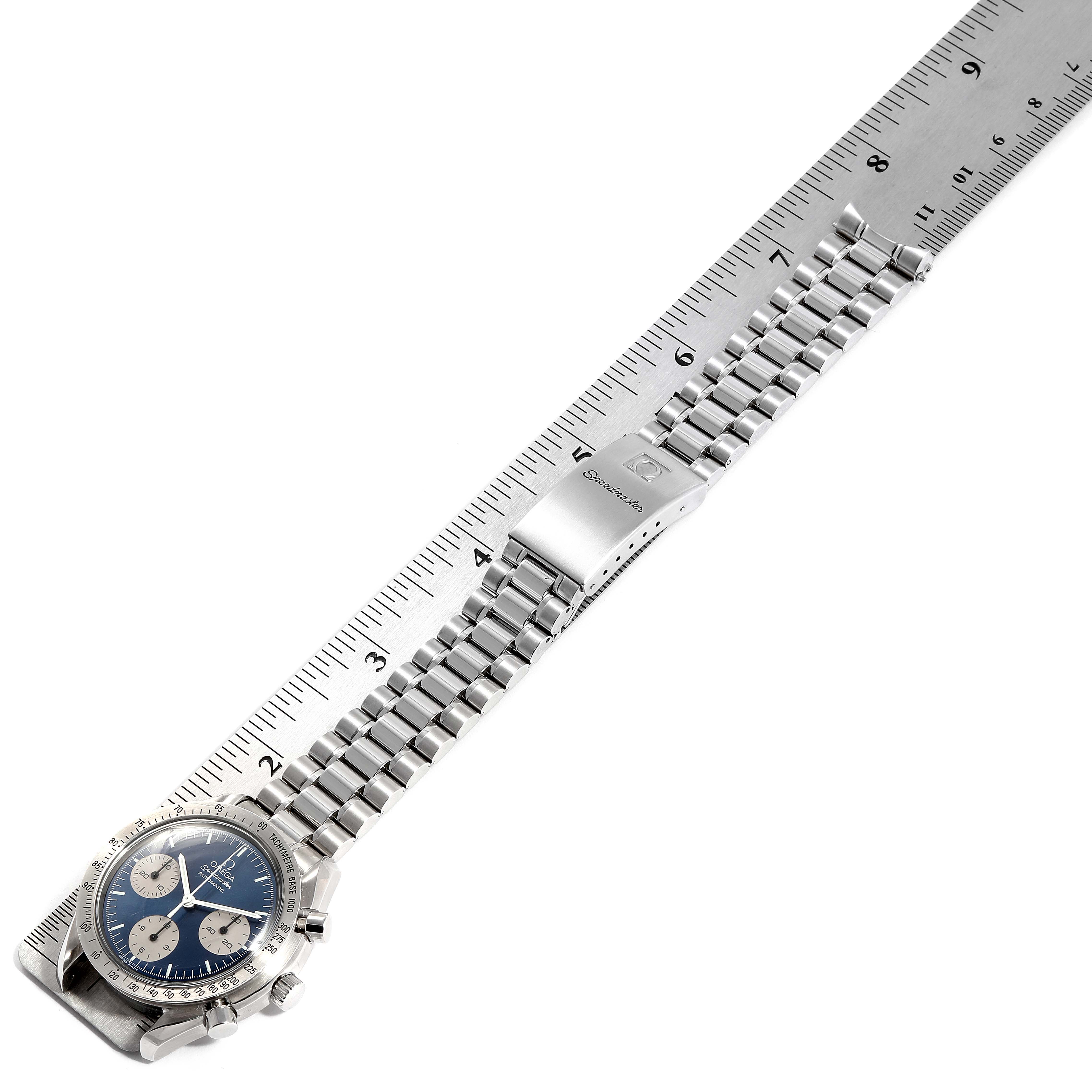 This image shows an Omega Speedmaster 3510.82.00 Men's Stainless Steel Blue Dial 3510.82.00 Men's Stainless Steel Blue Dial watch laid flat next to a ruler, highlighting its face, bracelet, and clasp.