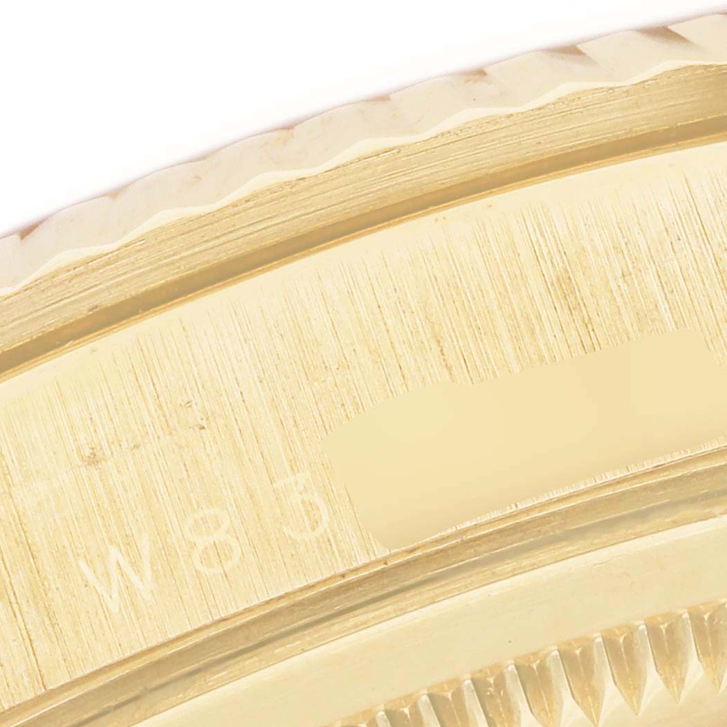 This close-up image of a Rolex President 18238 Men's Yellow Gold Mother of Pearl Dial 18238 Men's Yellow Gold Mother of Pearl Dial model watch shows the gold fluted bezel and part of the case with a serial number partially visible.