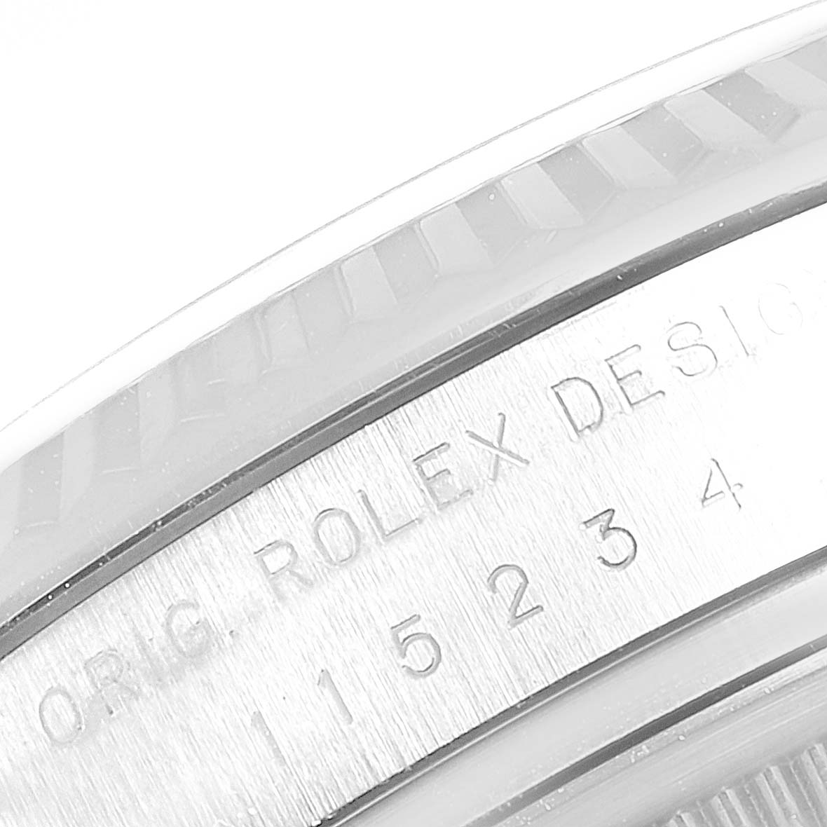 This image shows the side view of a Rolex Date 115234 Men's Stainless Steel Black Dial 115234 Men's Stainless Steel Black Dial model with part of its bezel and engraved serial number.