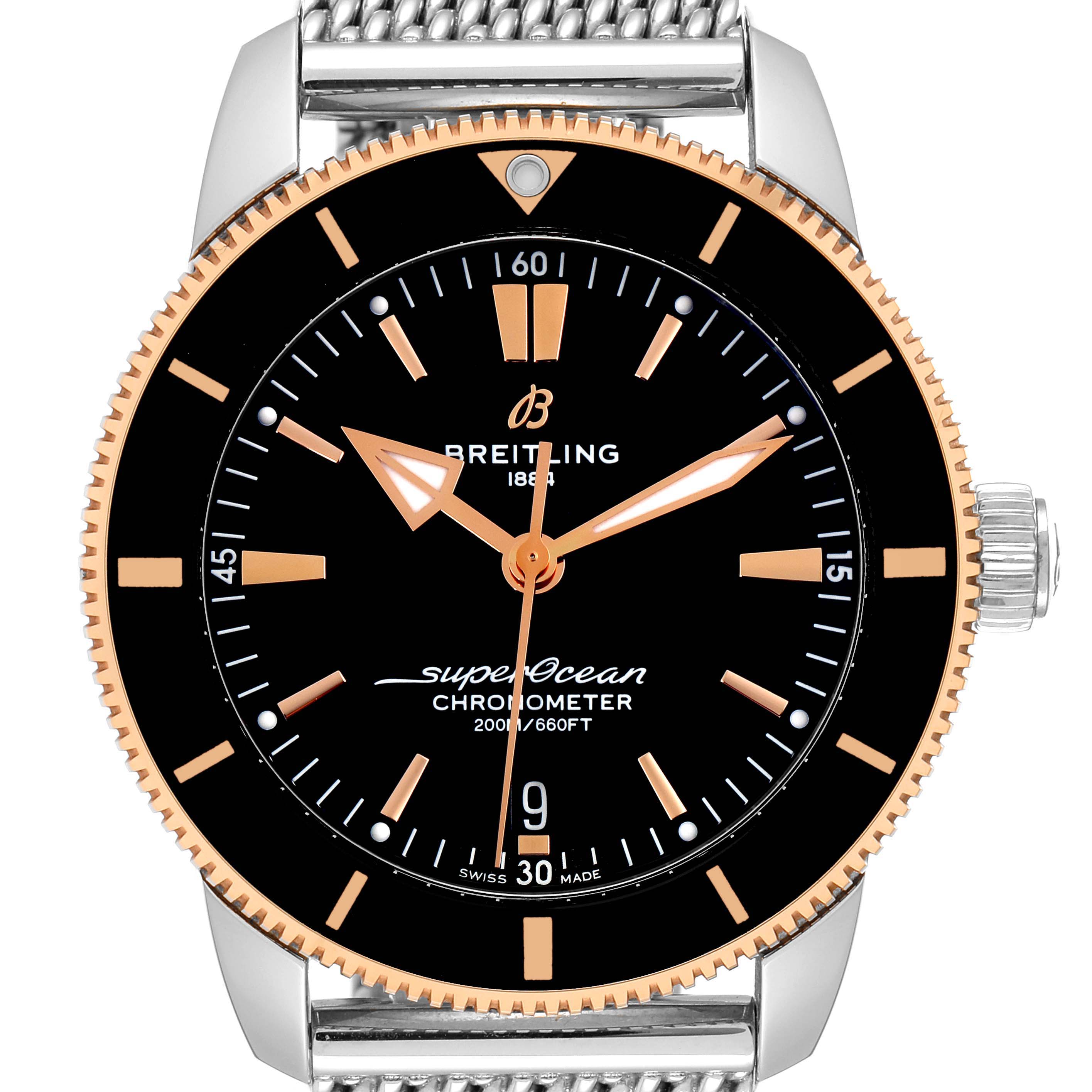 This is a front view of the Breitling Superocean UB2030121B1A1 Men's Steel and Gold (two tone) Black Dial UB2030121B1A1 Men's Steel and Gold (two tone) Black Dial watch, showcasing its black dial, gold accents, and a metal mesh strap.