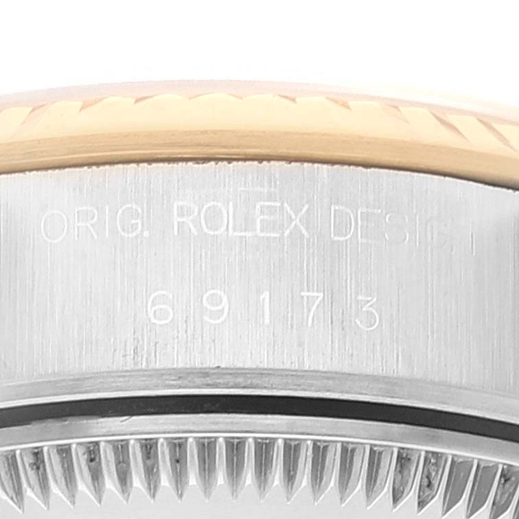 This close-up image of a Rolex Datejust 69173 Women's Steel and Gold (two tone) White Dial 69173 Women's Steel and Gold (two tone) White Dial watch shows the case side with engravings.