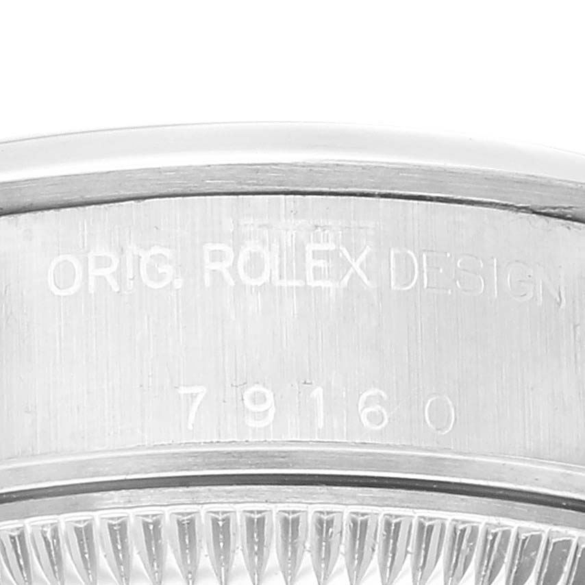 This close-up image shows the engraved serial number and "ORIG. ROLEX DESIGN" on the case of a Rolex Date 79160 Women's Stainless Steel White Dial 79160 Women's Stainless Steel White Dial watch.