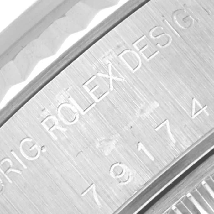 The image shows a close-up of the serial number and "Rolex Design" inscription on the side of a Rolex Datejust 79174 Women's Stainless Steel Silver Dial 79174 Women's Stainless Steel Silver Dial watch case.