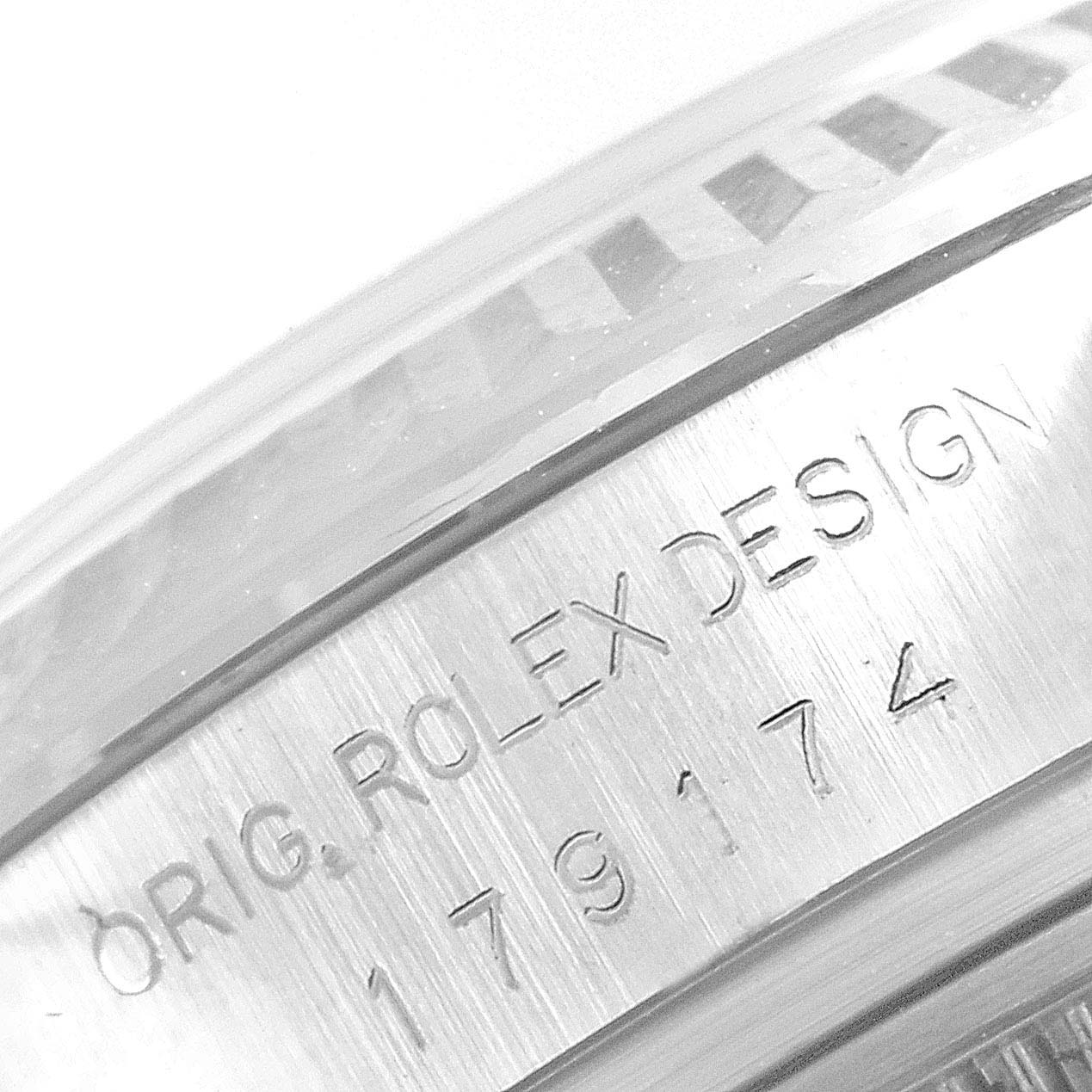 The image shows an angled close-up of the side of a Rolex Datejust 179174 Women's Stainless Steel Blue Dial 179174 Women's Stainless Steel Blue Dial watch case, highlighting its engraved details.