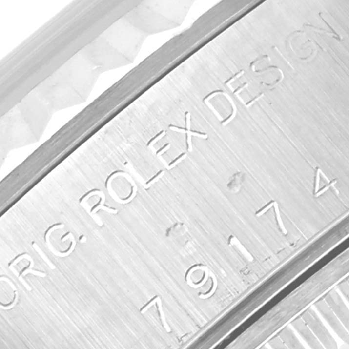 This close-up shows the Rolex Datejust 79174 Women's Stainless Steel Silver Dial 79174 Women's Stainless Steel Silver Dial watch's inner bezel with "ORIG. ROLEX DESIGN" and serial number engraving.