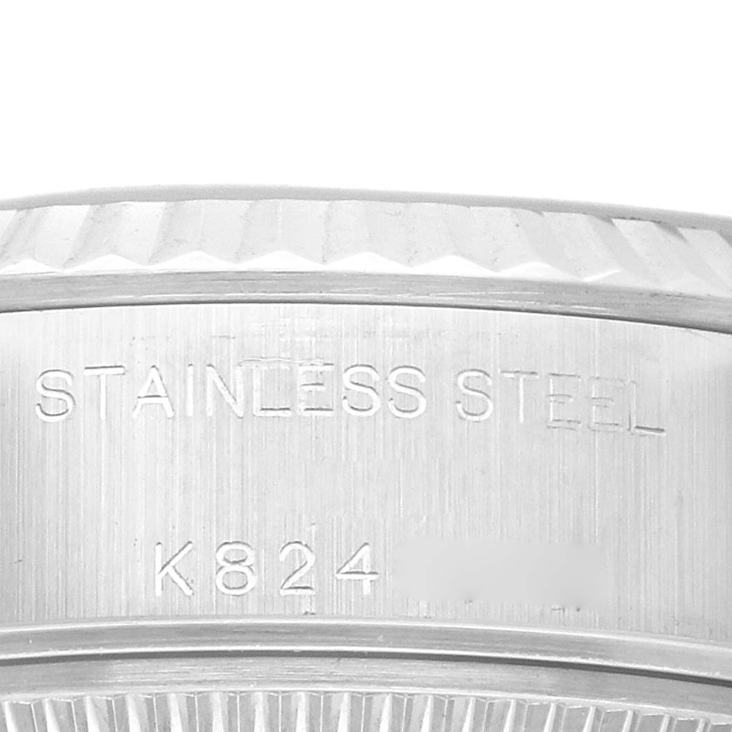 This close-up image shows the side of the stainless steel case back of a Rolex Datejust 79174 Women's Stainless Steel Blue Dial 79174 Women's Stainless Steel Blue Dial watch.