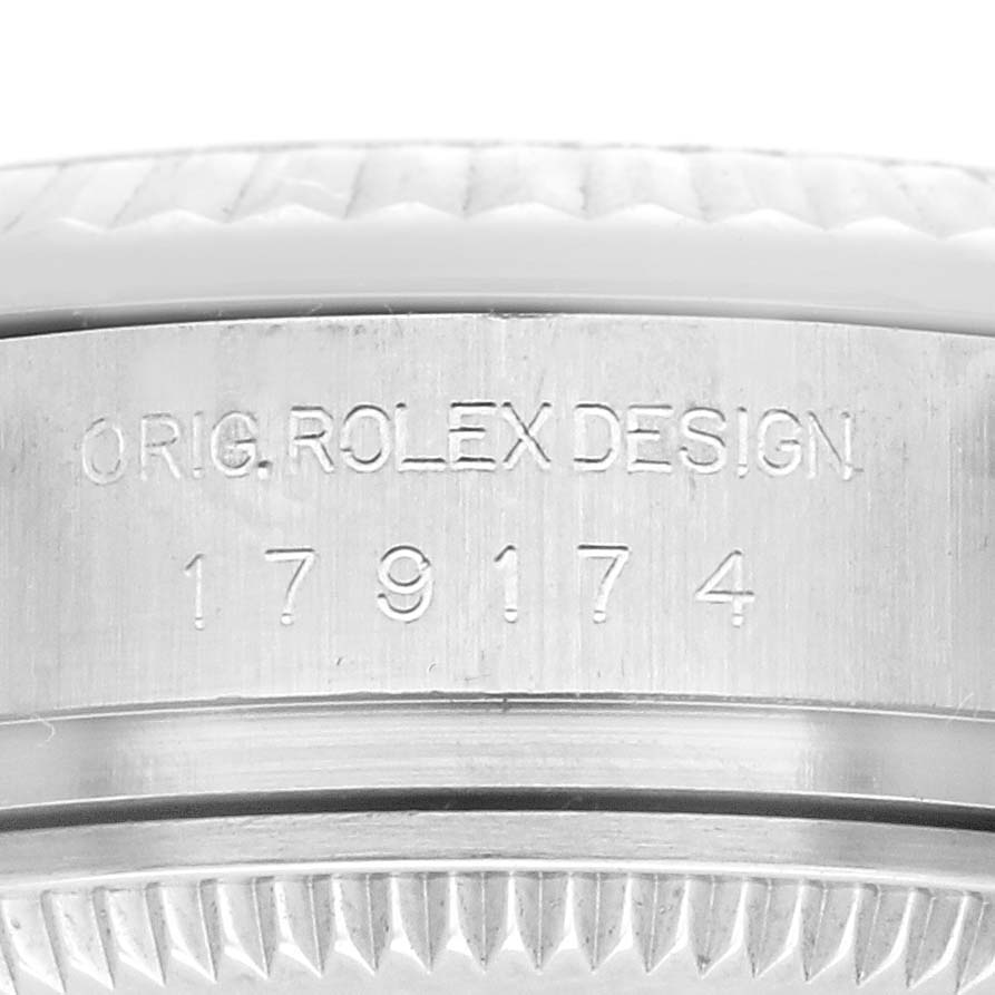 The image shows a close-up of the case side of a Rolex Datejust 179174 Women's Stainless Steel Black Dial 179174 Women's Stainless Steel Black Dial, highlighting the engraved model number and "O.RIG. ROLEX DESIGN."