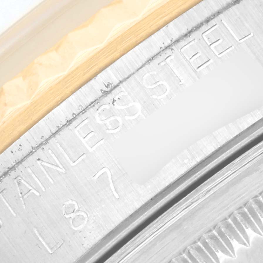 This image shows a close-up of the stainless steel casing and fluted bezel of a Rolex Datejust 16233 Men's Steel and Gold (two tone) Champagne Dial 16233 Men's Steel and Gold (two tone) Champagne Dial watch.