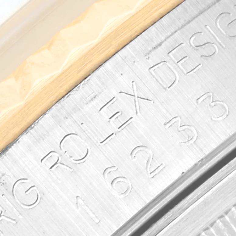 The image shows a close-up view of the engraved side of the Rolex Datejust 16233 Men's Steel and Gold (two tone) Champagne Dial 16233 Men's Steel and Gold (two tone) Champagne Dial watch, highlighting text and part of the bezel.