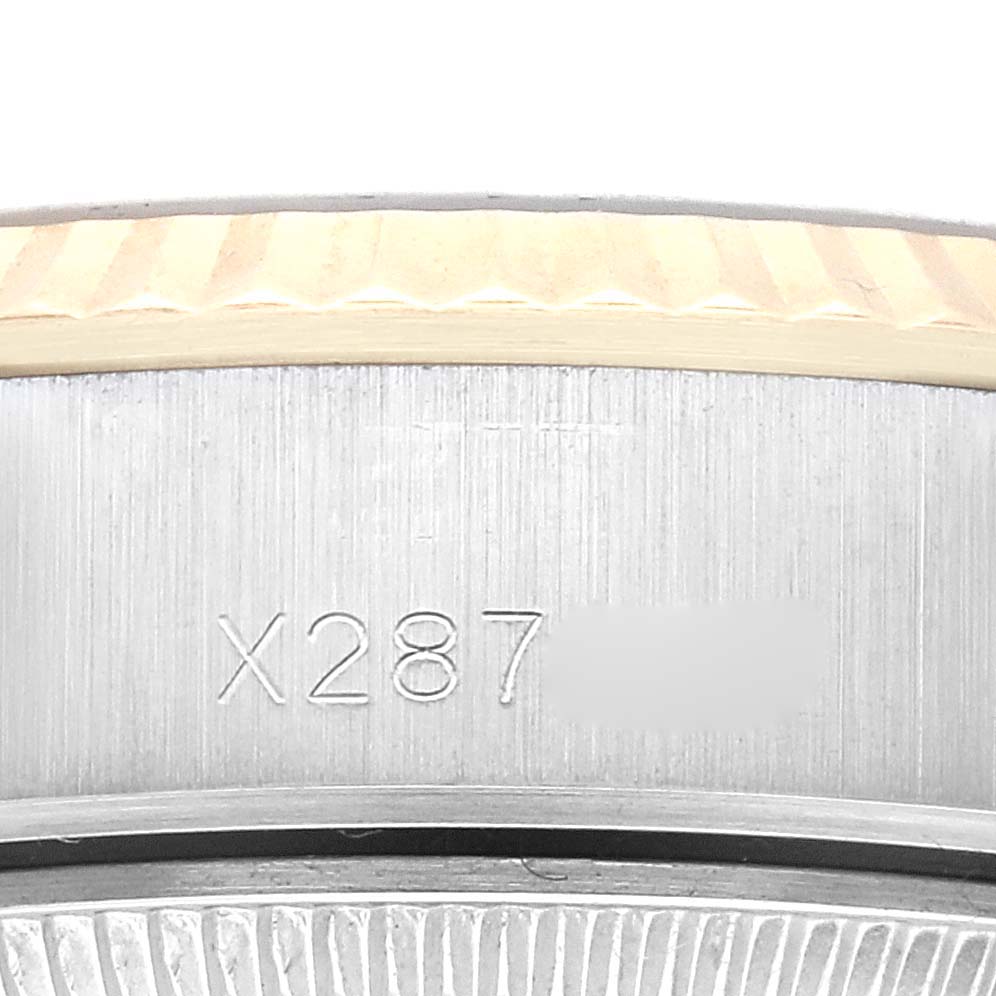 The image shows a close-up of a serial number engraving on the side of a Rolex Datejust 69173G Women's Steel and Gold (two tone) Champagne Dial 69173G Women's Steel and Gold (two tone) Champagne Dial watch case.