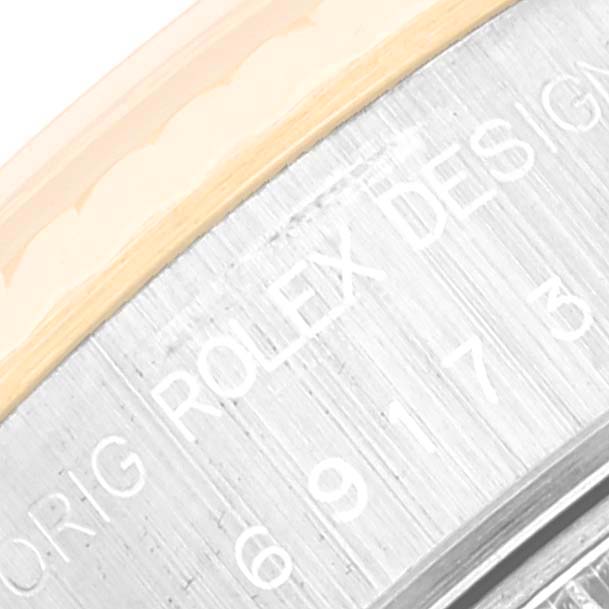 This image shows an angled close-up of the engraved lettering on the back of a Rolex Datejust 69173 Women's Steel and Gold (two tone) Blue Dial 69173 Women's Steel and Gold (two tone) Blue Dial watch.