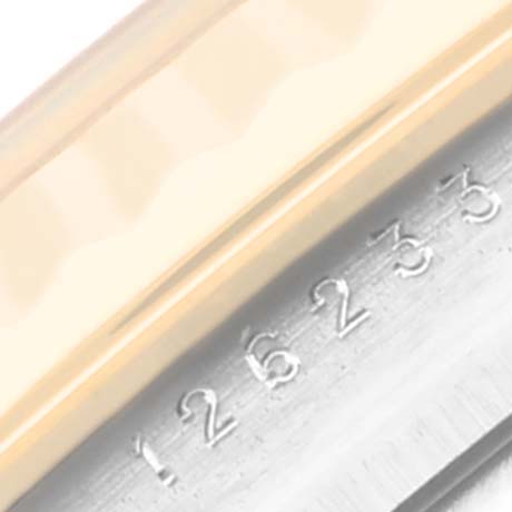 This close-up image of the Rolex Datejust 126233 Men's Steel and Gold (two tone) Champagne Dial 126233 Men's Steel and Gold (two tone) Champagne Dial watch shows part of the bezel and the serial number engraving on the case.