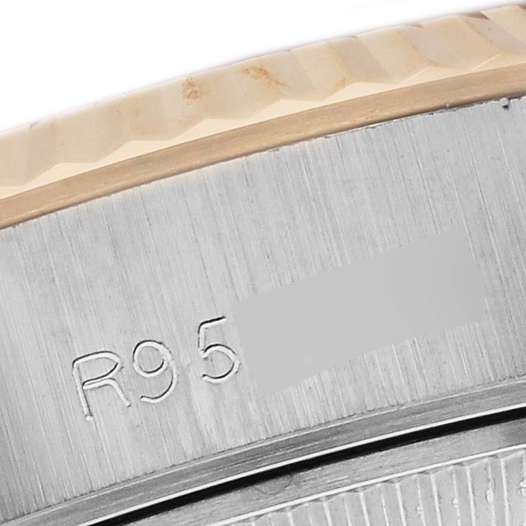 This is a close-up image showing the bezel and part of the case of a Rolex Datejust 69173 Women's Steel and Gold (two tone) Champagne Dial 69173 Women's Steel and Gold (two tone) Champagne Dial watch with a visible engraving.