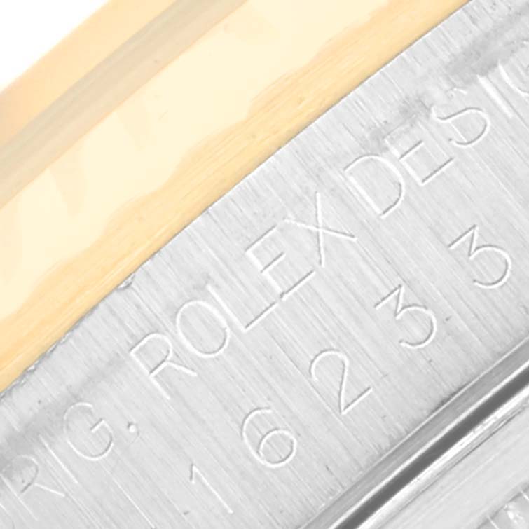 The image shows a close-up of the bezel and engraved case of a Rolex Datejust 16233 Men's Steel and Gold (two tone) Champagne Dial 16233 Men's Steel and Gold (two tone) Champagne Dial watch.