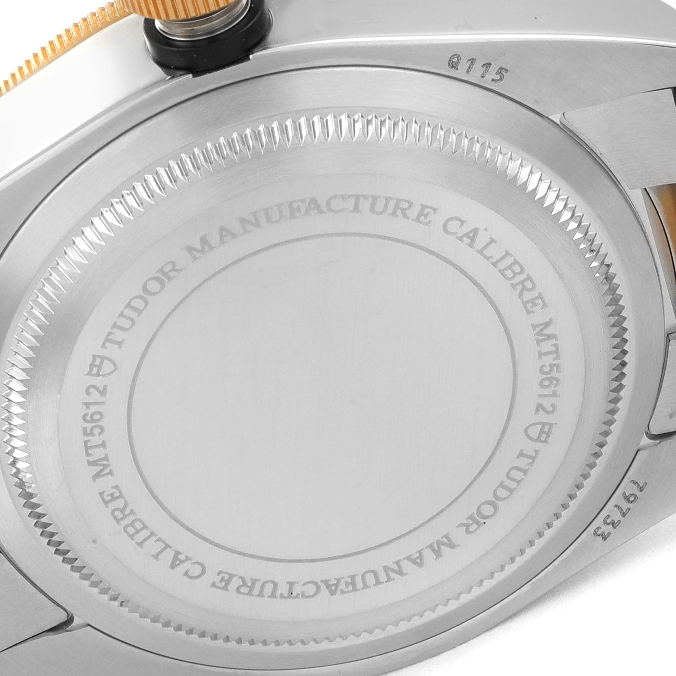 The image shows a close-up of the case back of the Tudor Heritage Black Bay 79733 Men's Steel and Gold (two tone) Black Dial 79733 Men's Steel and Gold (two tone) Black Dial watch, highlighting the engravings and crown.