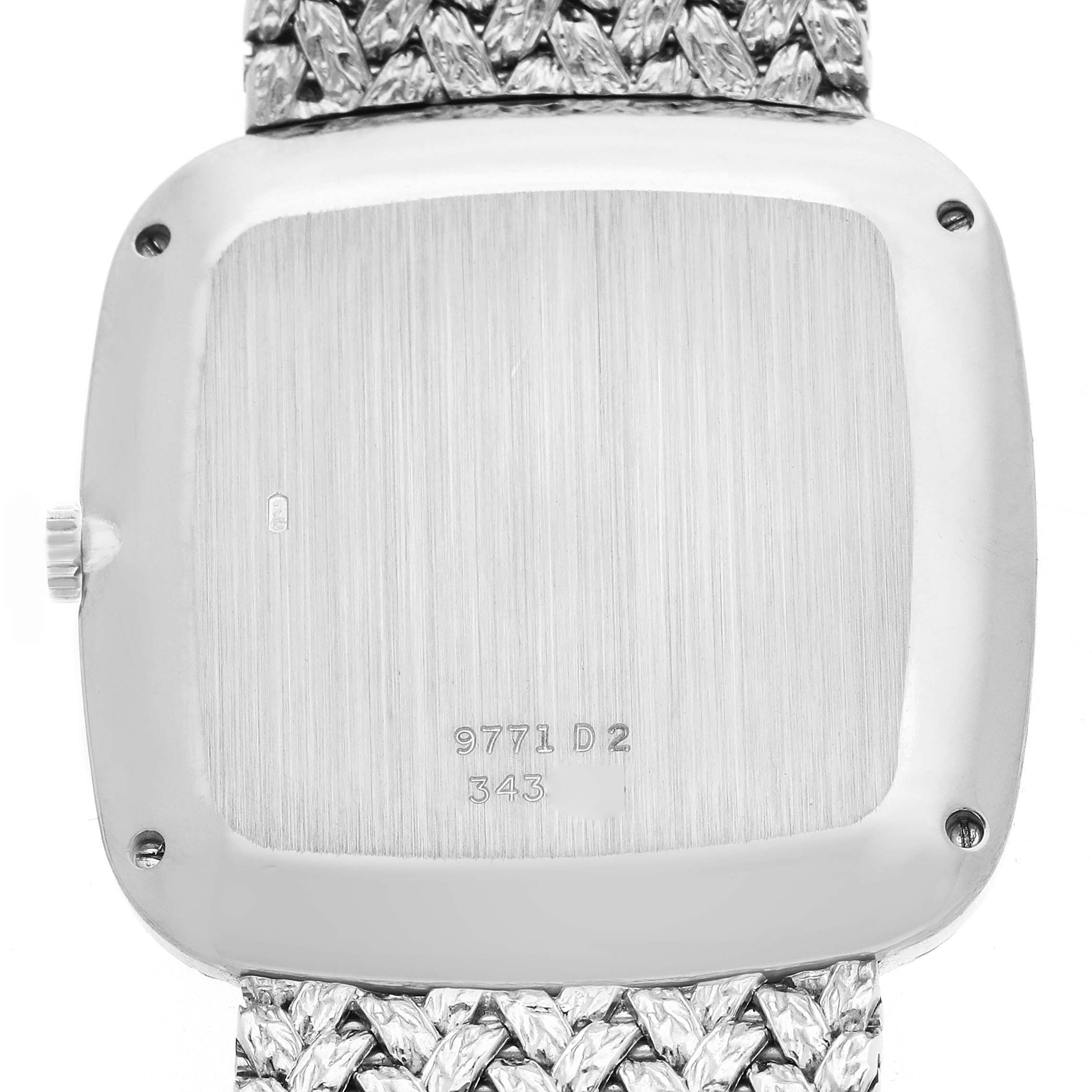 The image shows the back of a Piaget model 9771D2 men's watch, highlighting its case back with inscriptions and a portion of the textured bracelet.