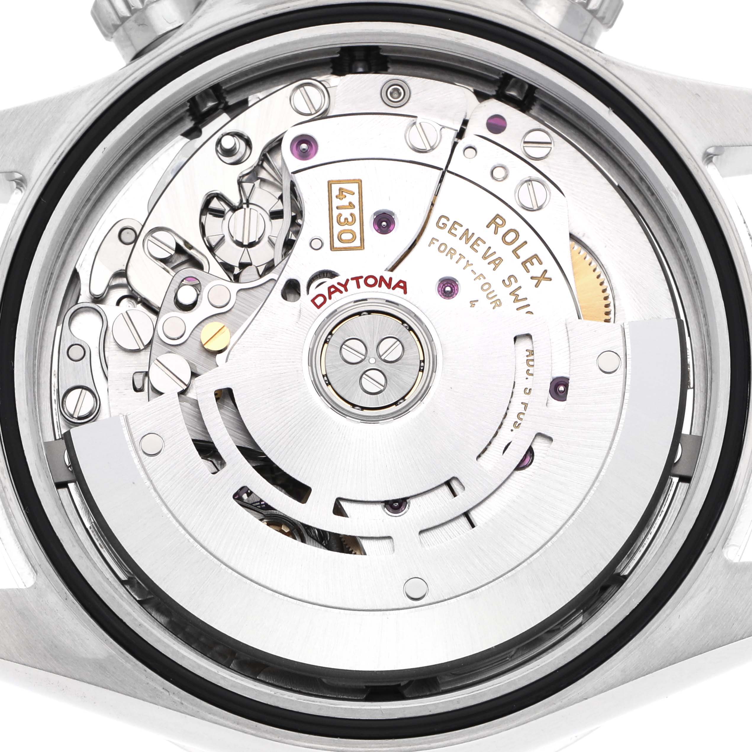 The image shows the movement of a Rolex Daytona, model number 116520, with its intricate internal mechanics visible from the back.