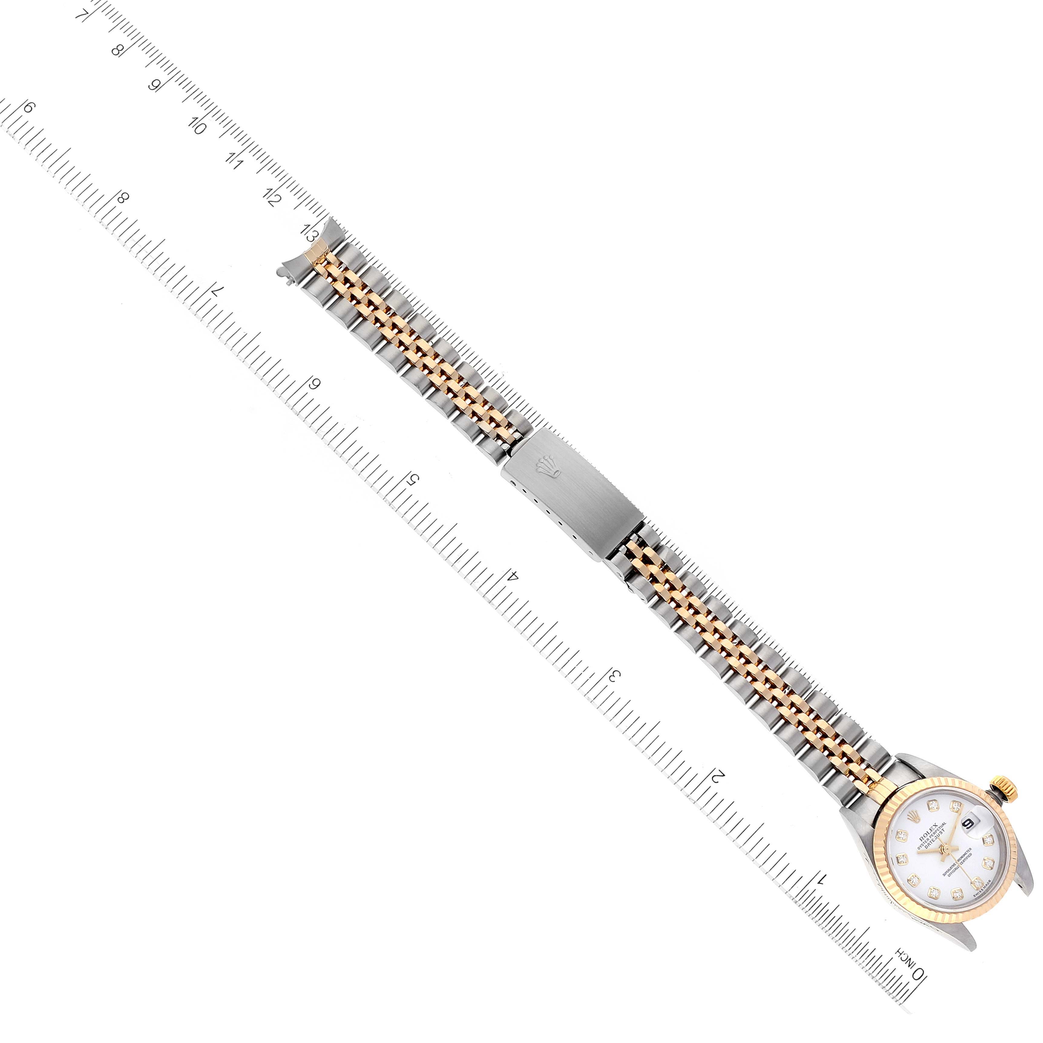 This image shows a Rolex Datejust 79173 Women's Steel and Gold (two tone) White Dial 79173 Women's Steel and Gold (two tone) White Dial watch laid flat, highlighting the band and dial beside a measuring ruler.