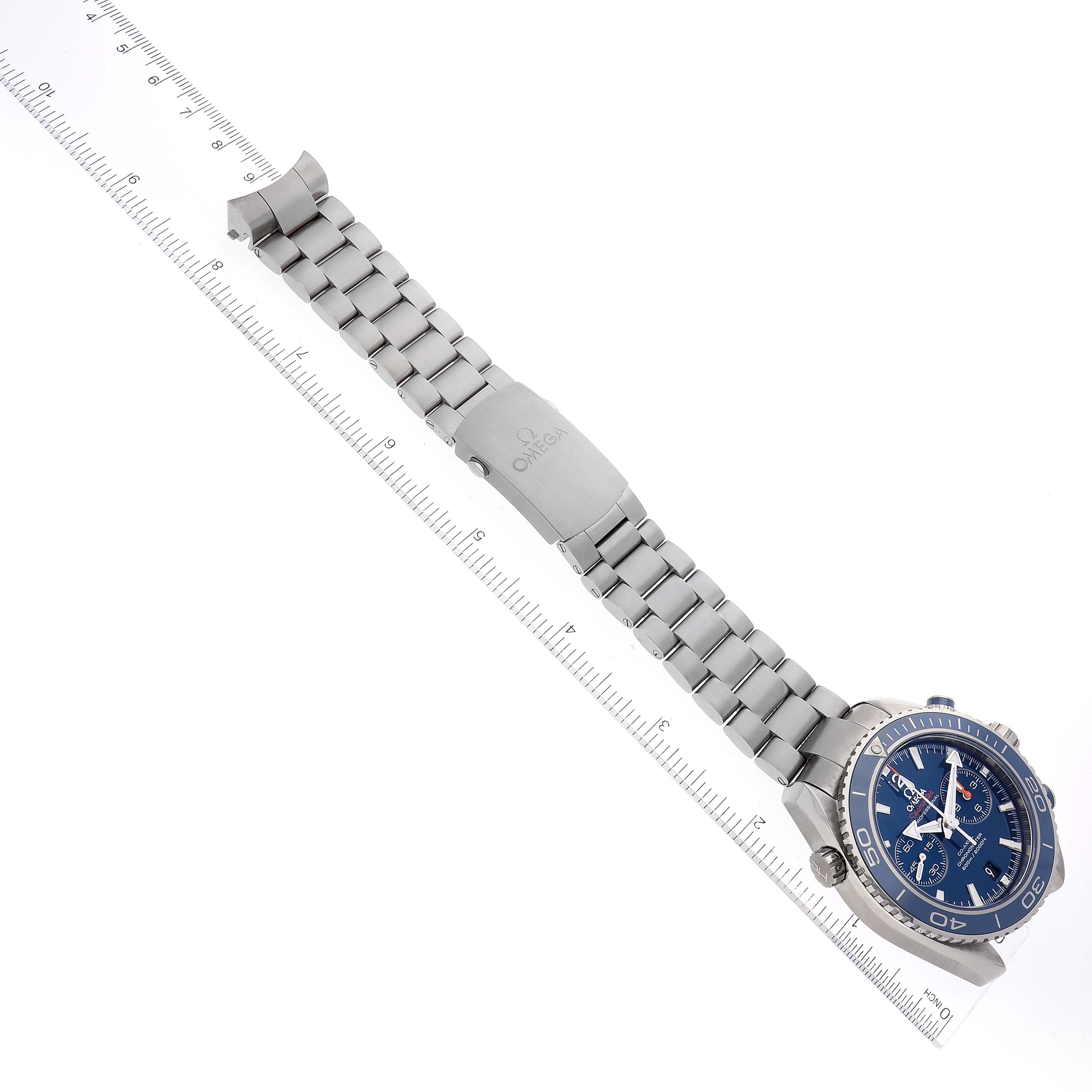 The image shows an Omega Planet Ocean 232.90.46.51.03.001 Men's Titanium Blue Dial 232.90.46.51.03.001 Men's Titanium Blue Dial watch laid flat with a ruler measuring its length.